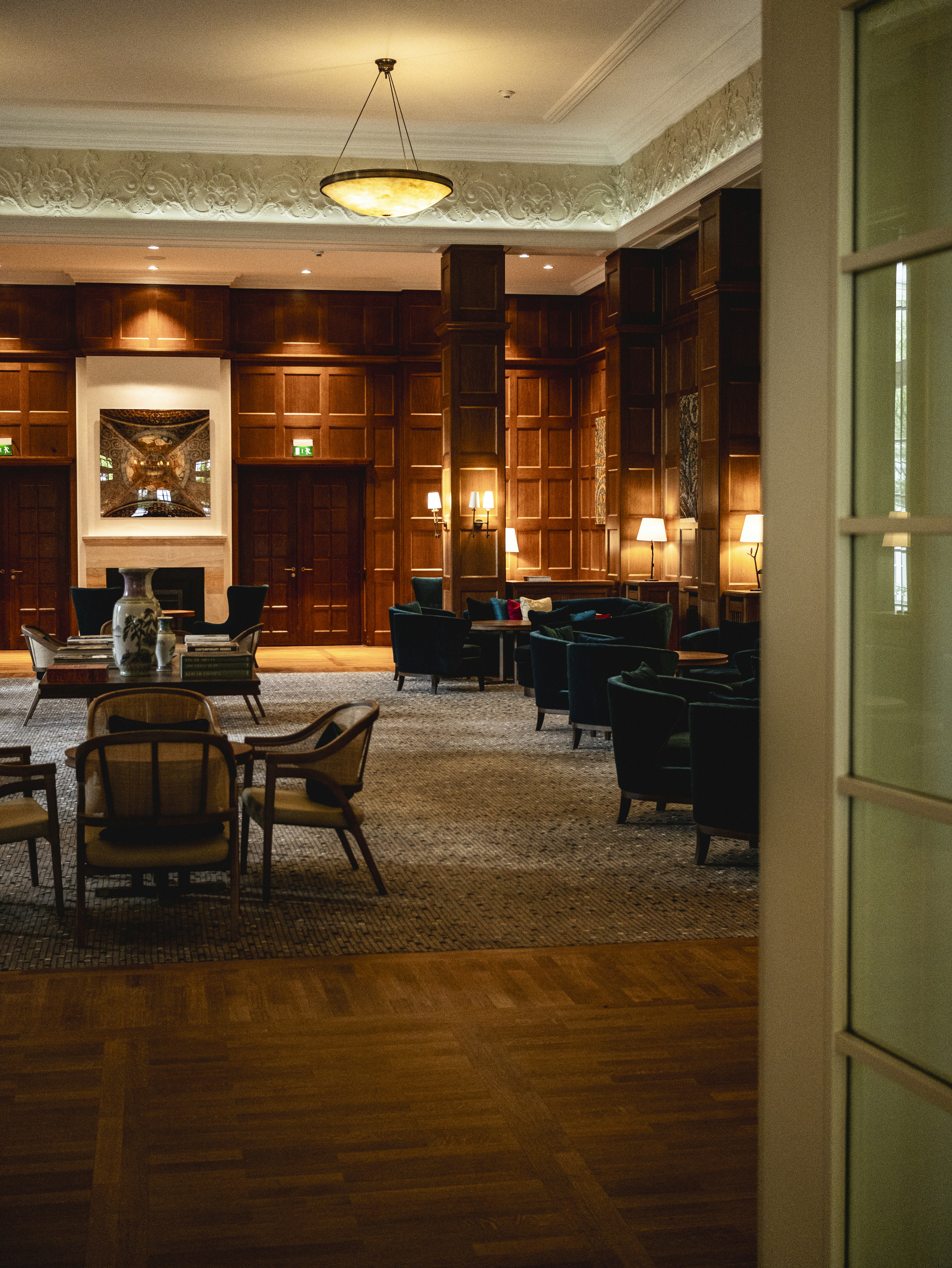 Elegante hall dell'hotel rivestita in legno con invitanti posti a sedere.