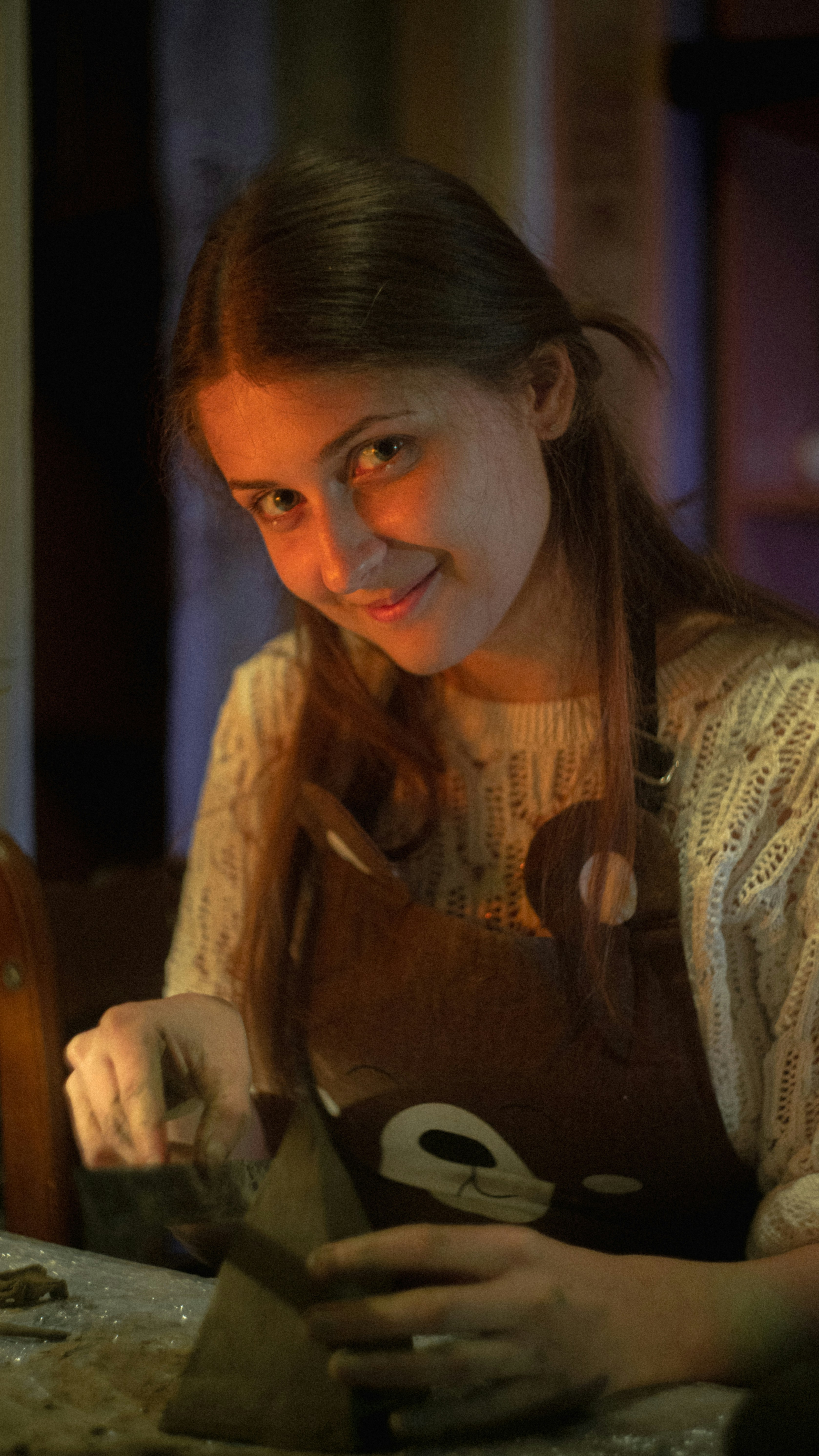 A woman smiles while working on a project.