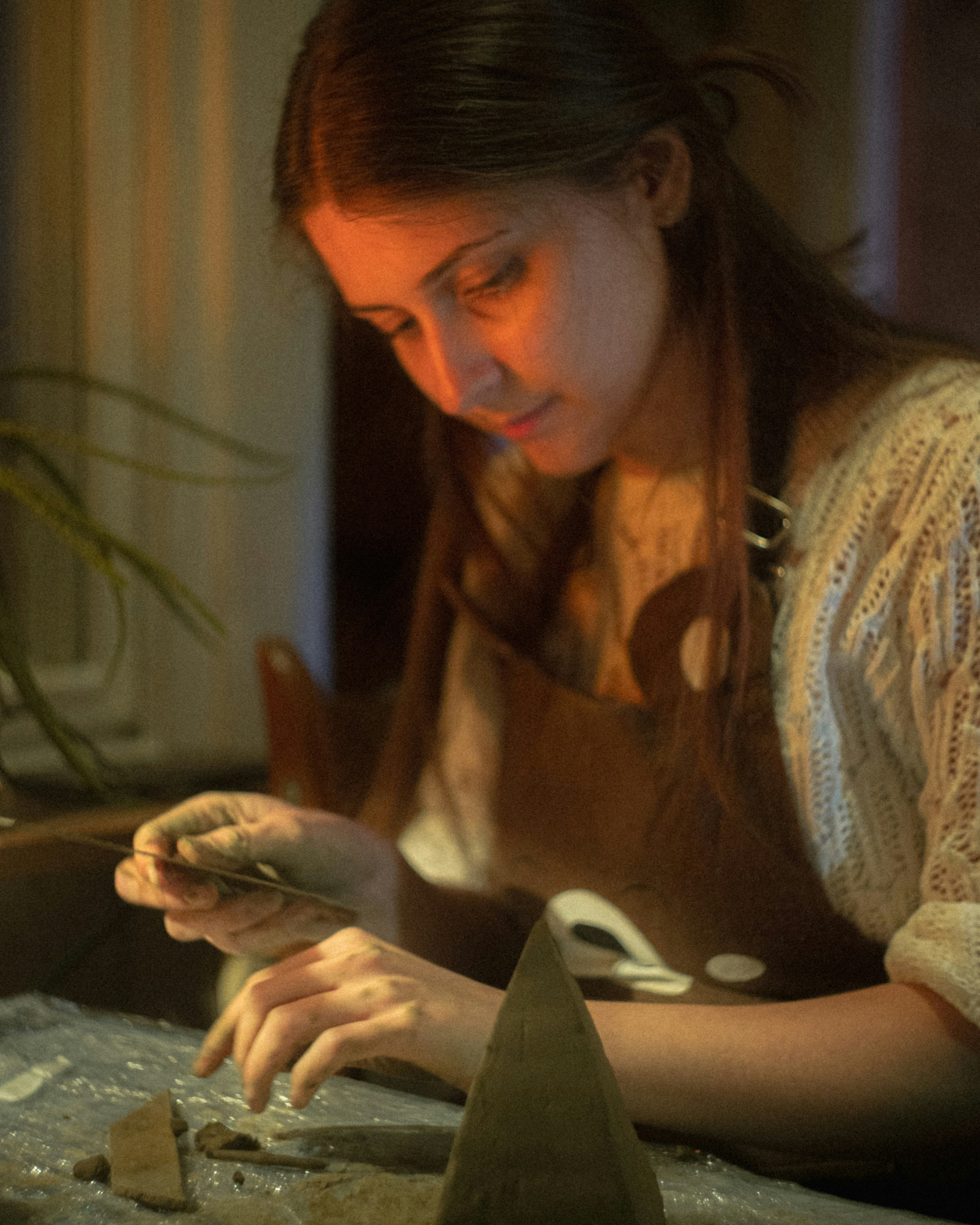Woman carefully works on a craft project.