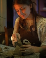 A woman is working on a craft project.