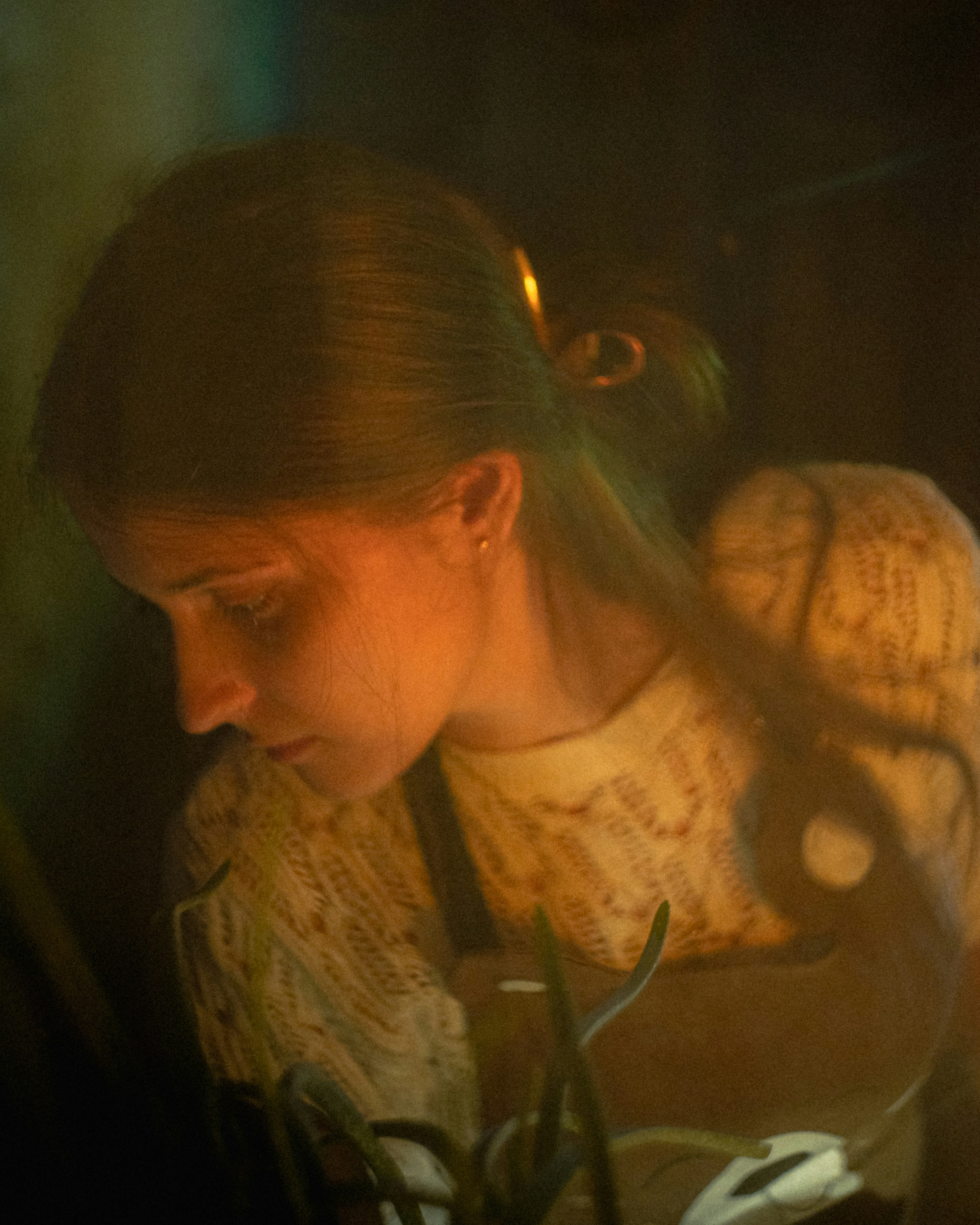 A young woman works under dim lighting.