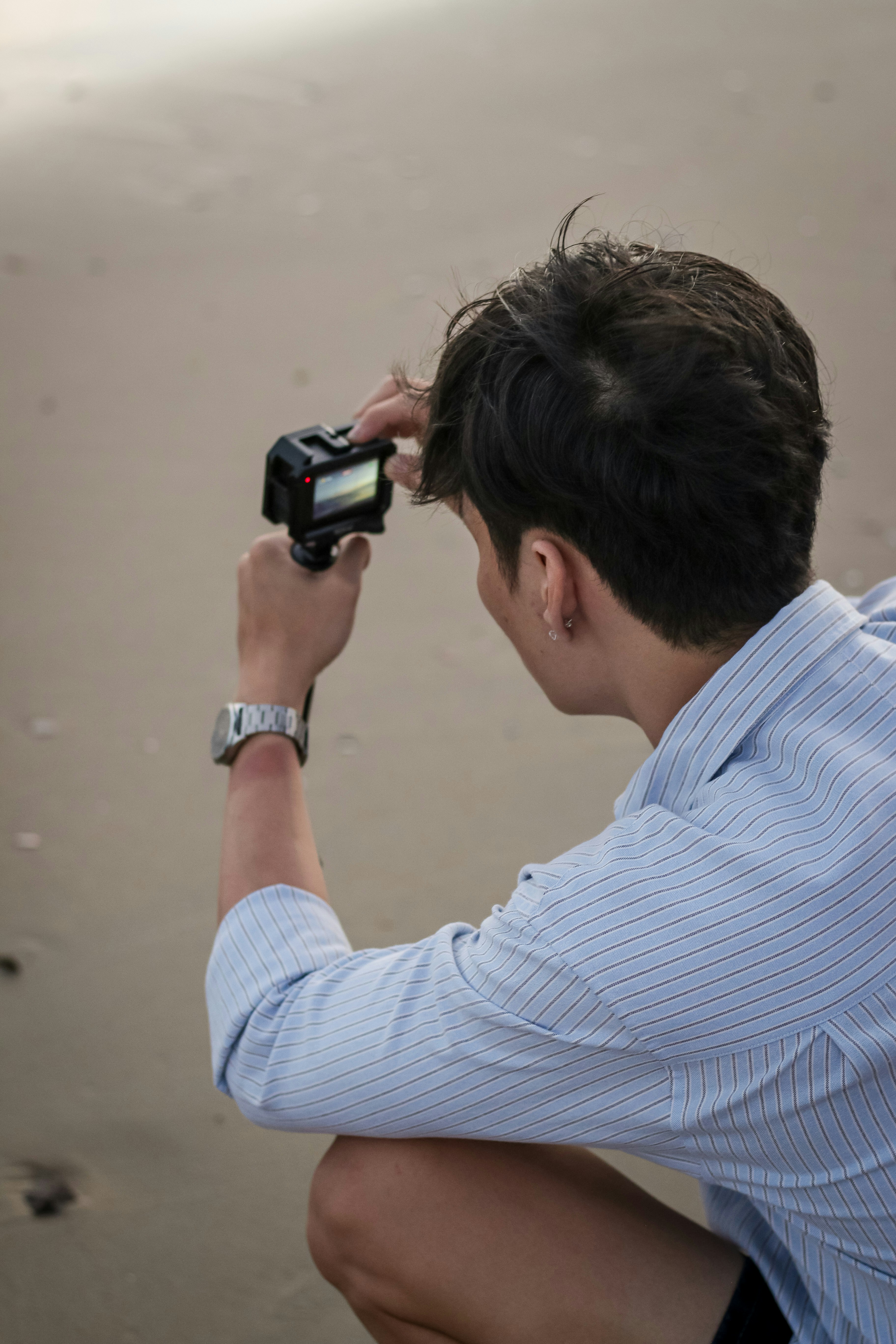 A man takes pictures on the beach.