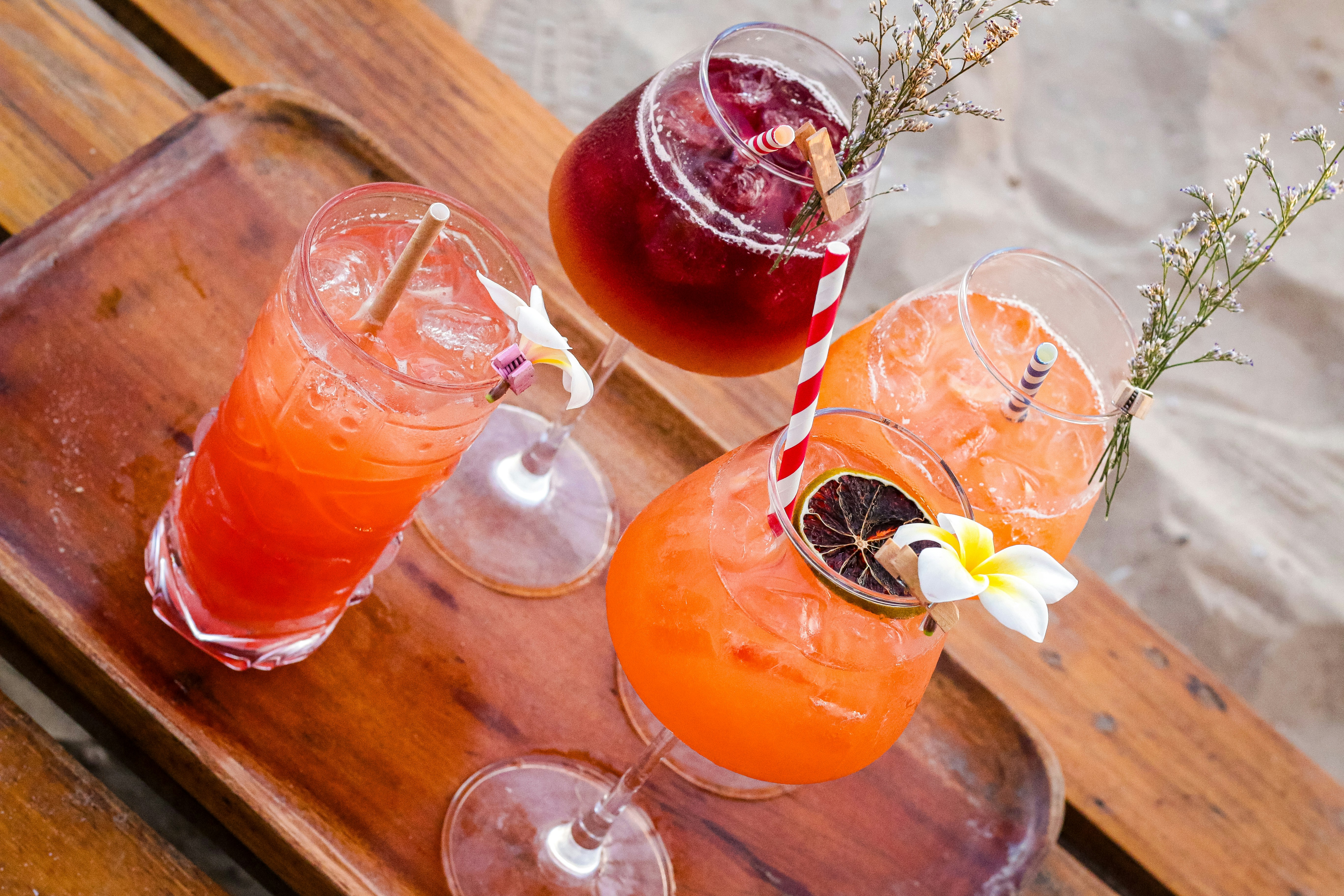 Colorful cocktails on a wooden tray.