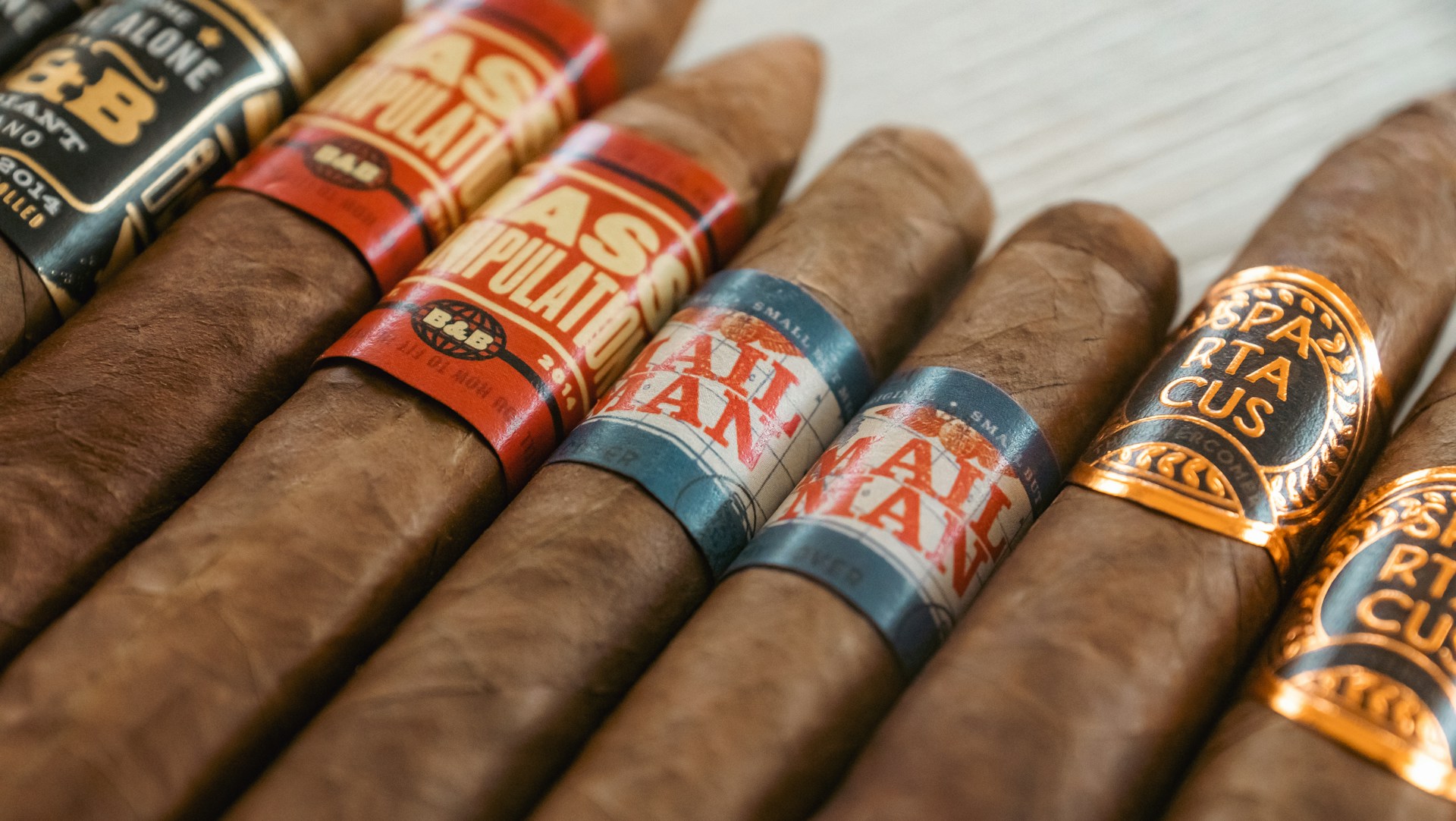 A variety of cigars with colorful bands.
