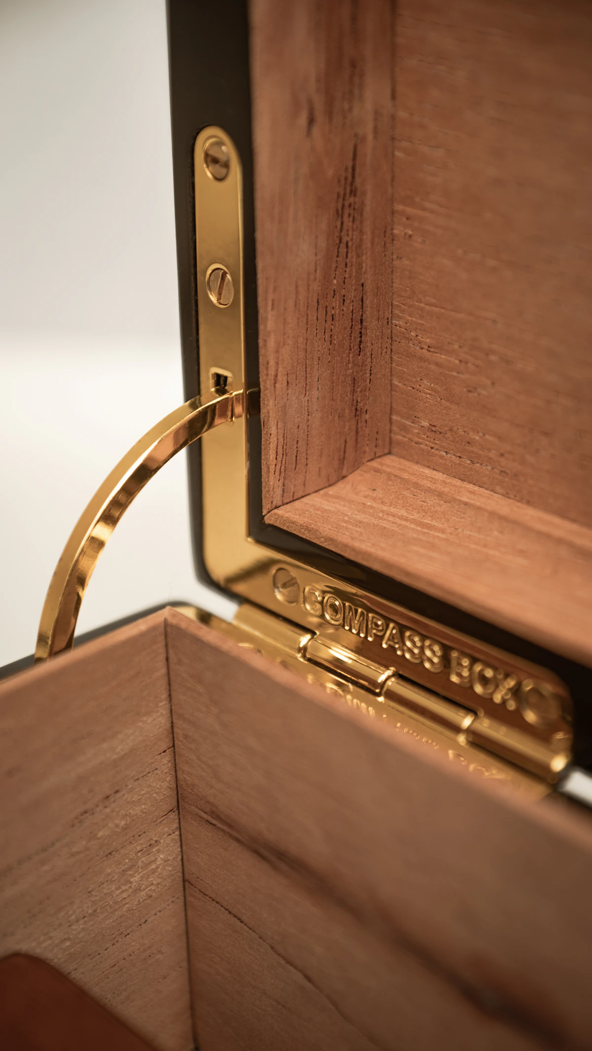 Detailed luxury humidor interior with polished gold hardware and cedar wood