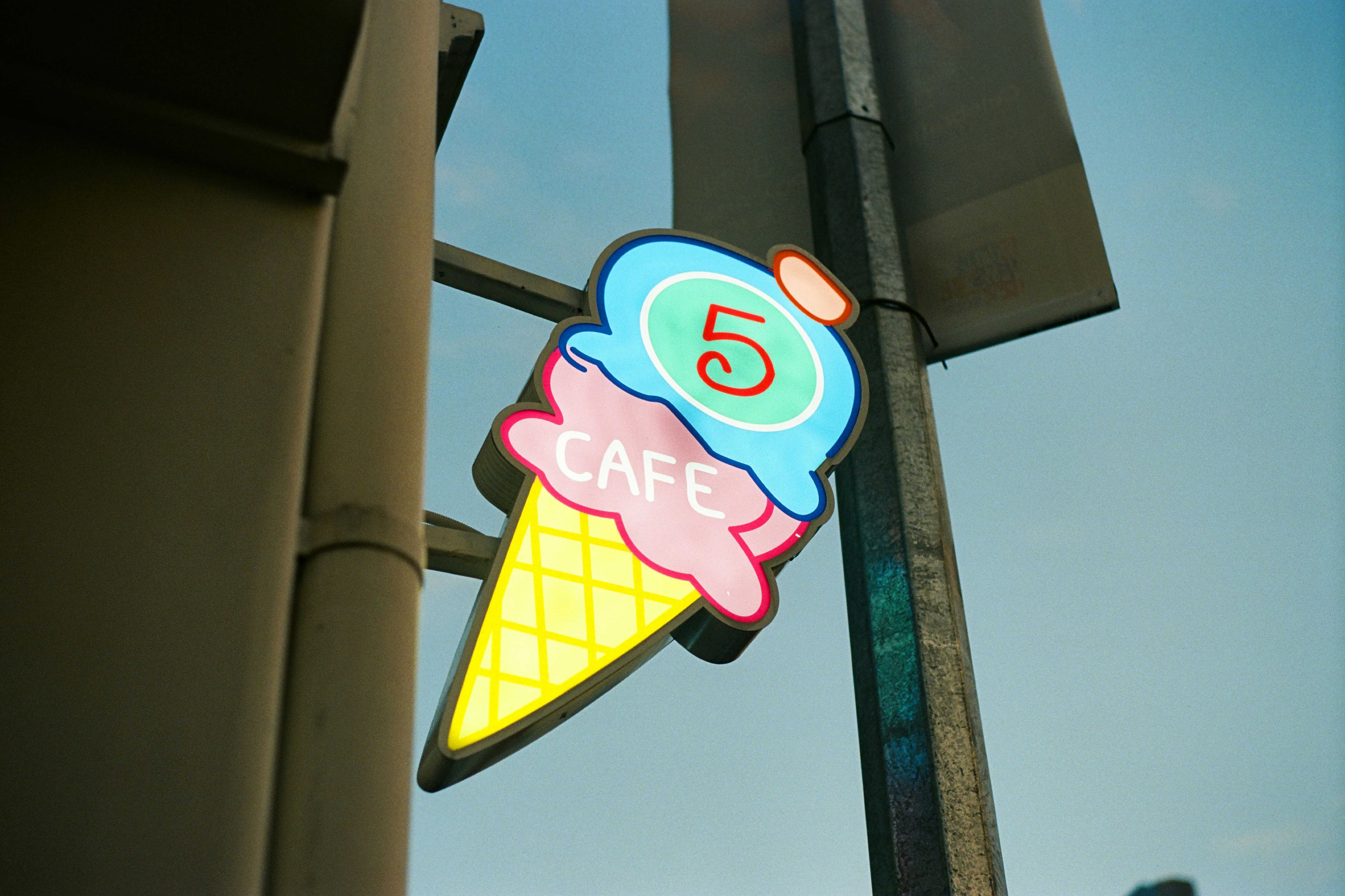 A neon ice cream cone cafe sign.