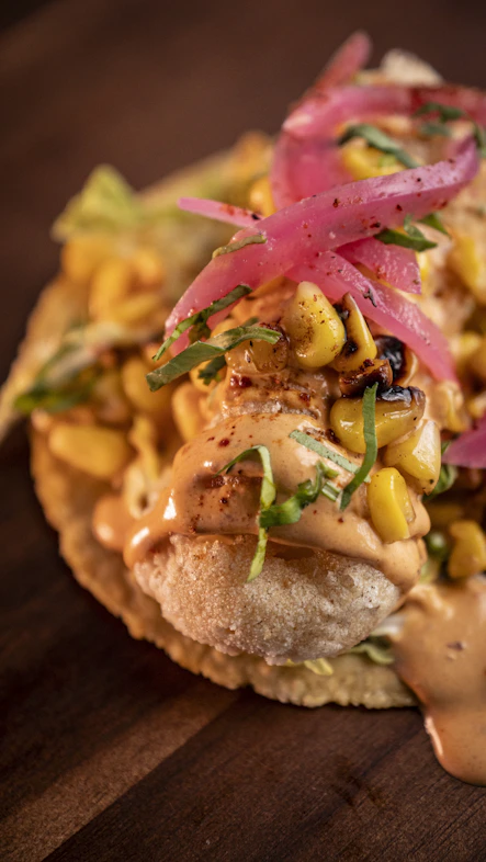 Delicious taco topped with corn and pickled onions.