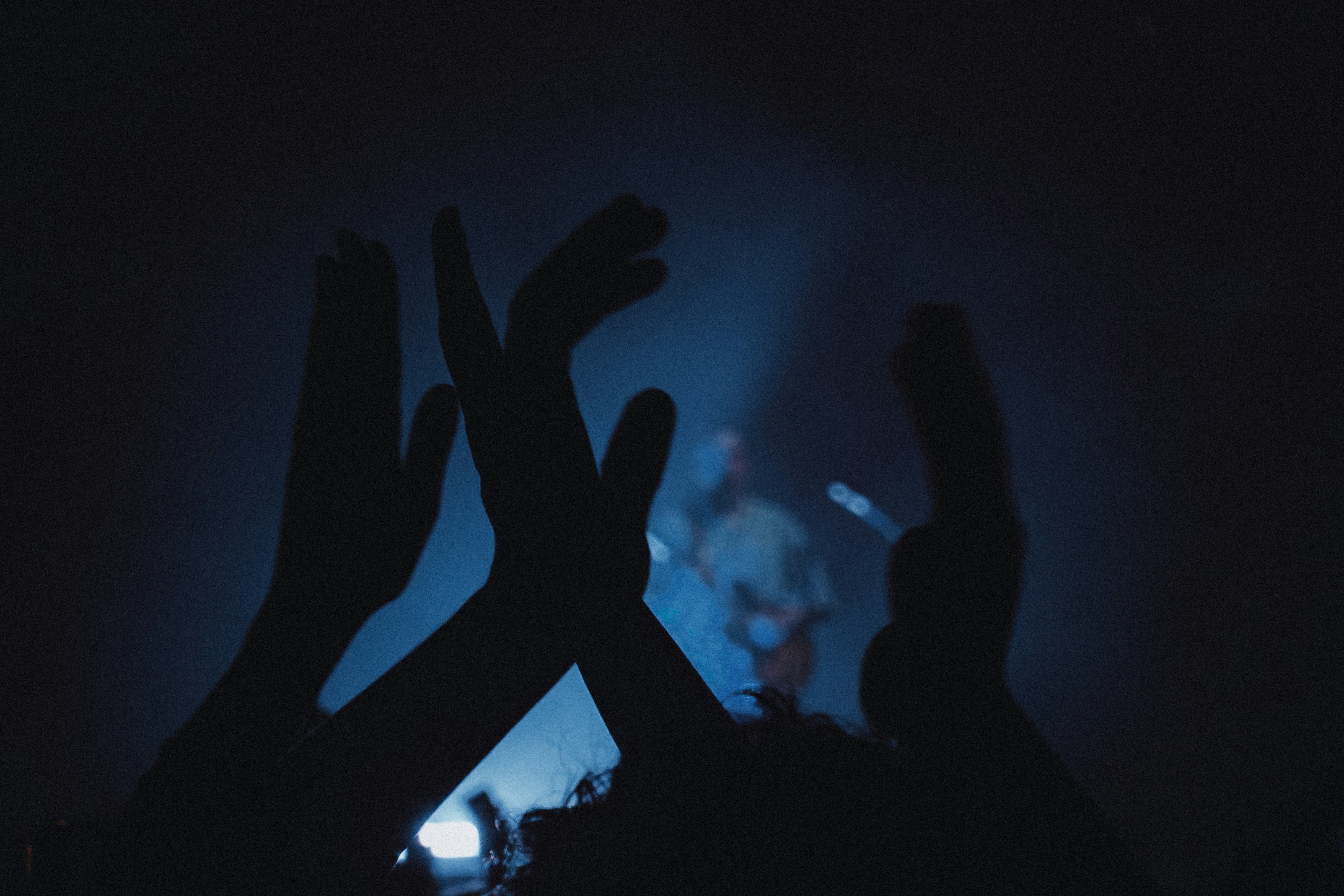 Audience claps hands during a concert.