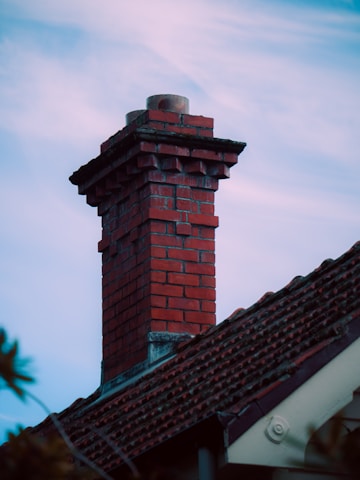 A red brick chimney against a blue sky.
