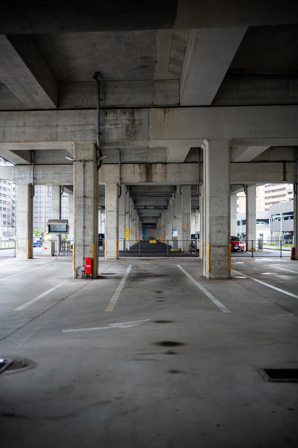 Enclosed multi-level parking garage with concrete pillars, lit at night