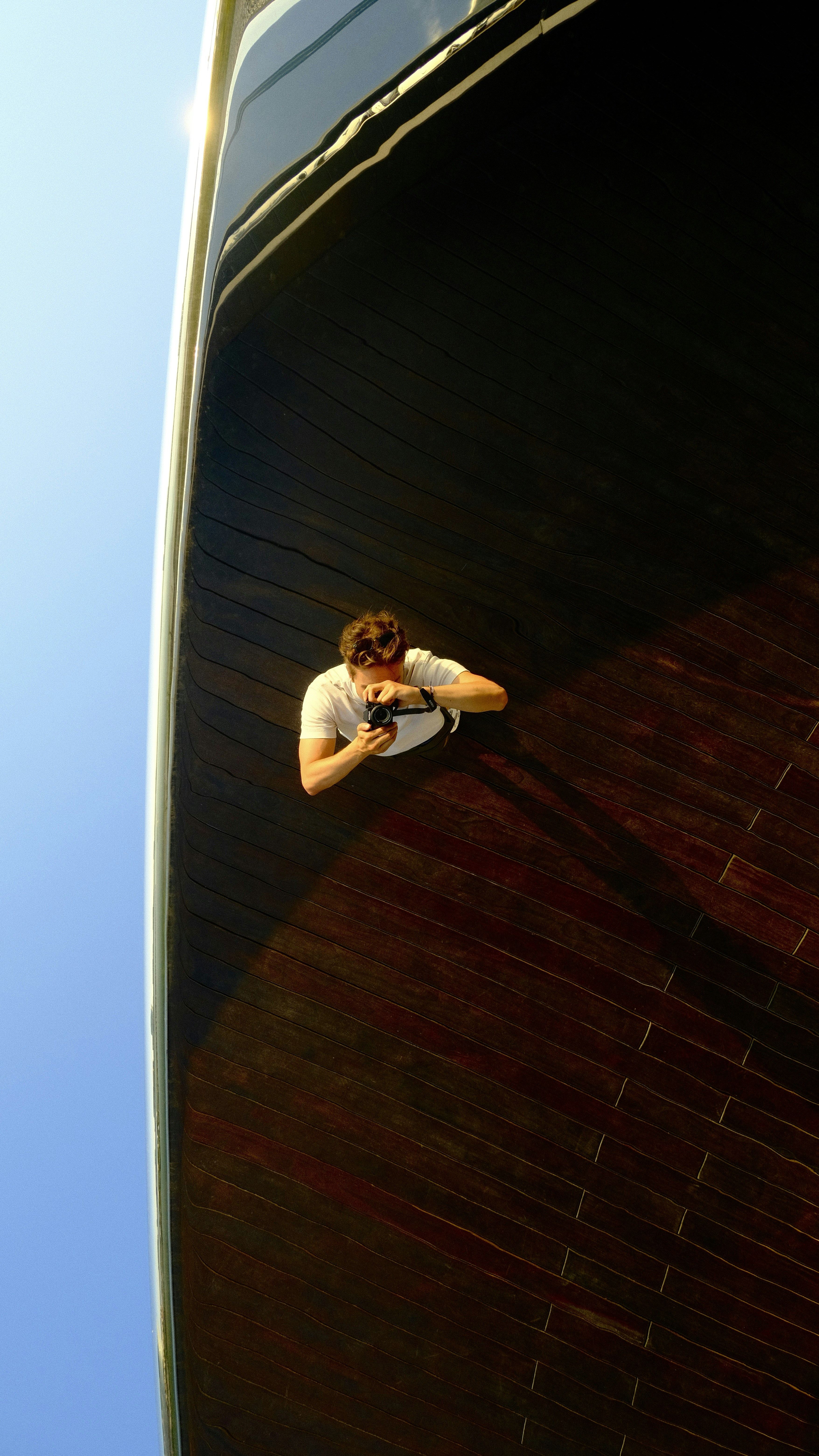 A man is taking a photo of a boat.
