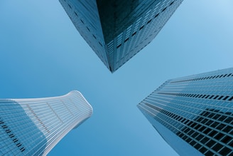 Three skyscrapers point upward against the blue sky.