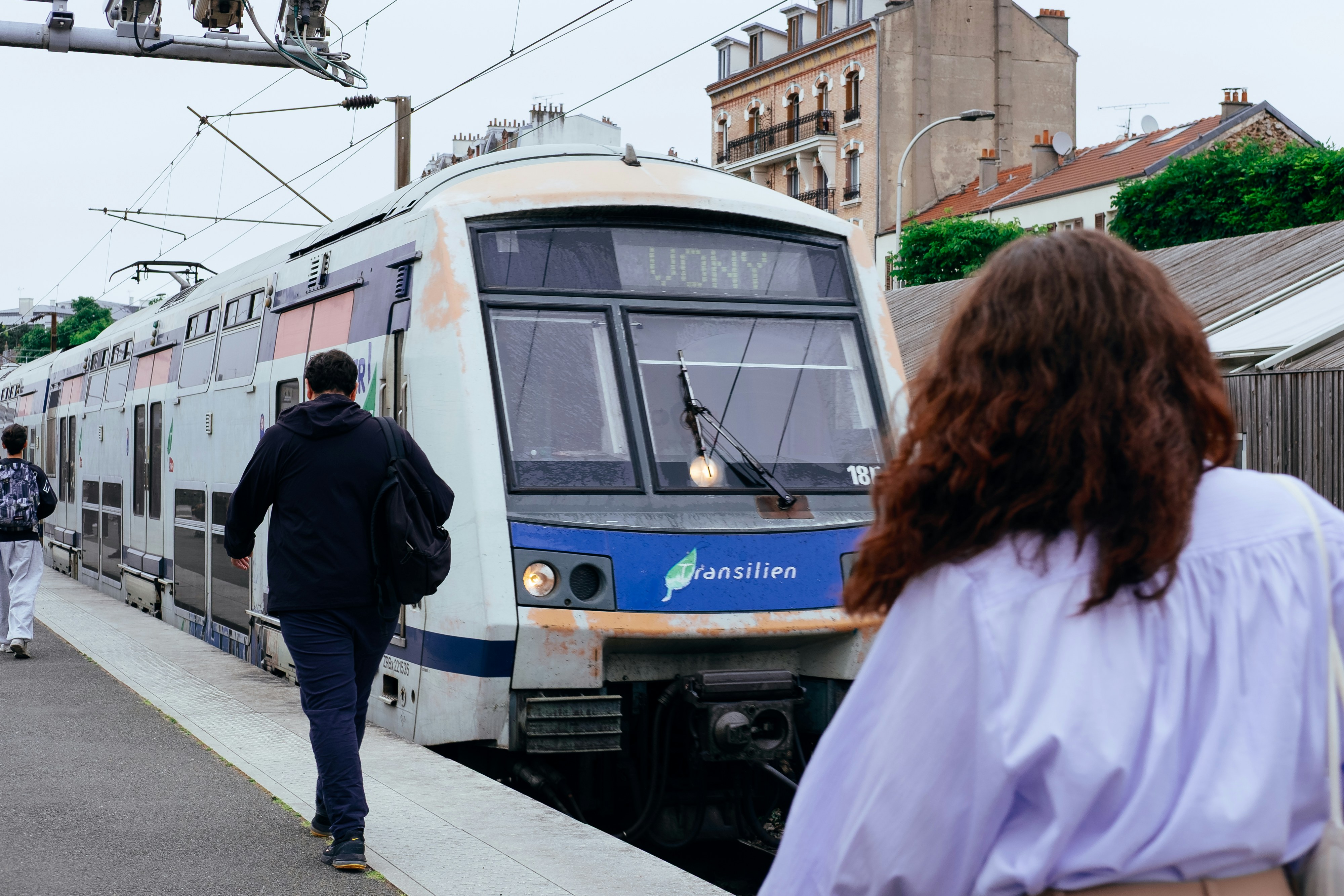 People wait at a train station platform.
