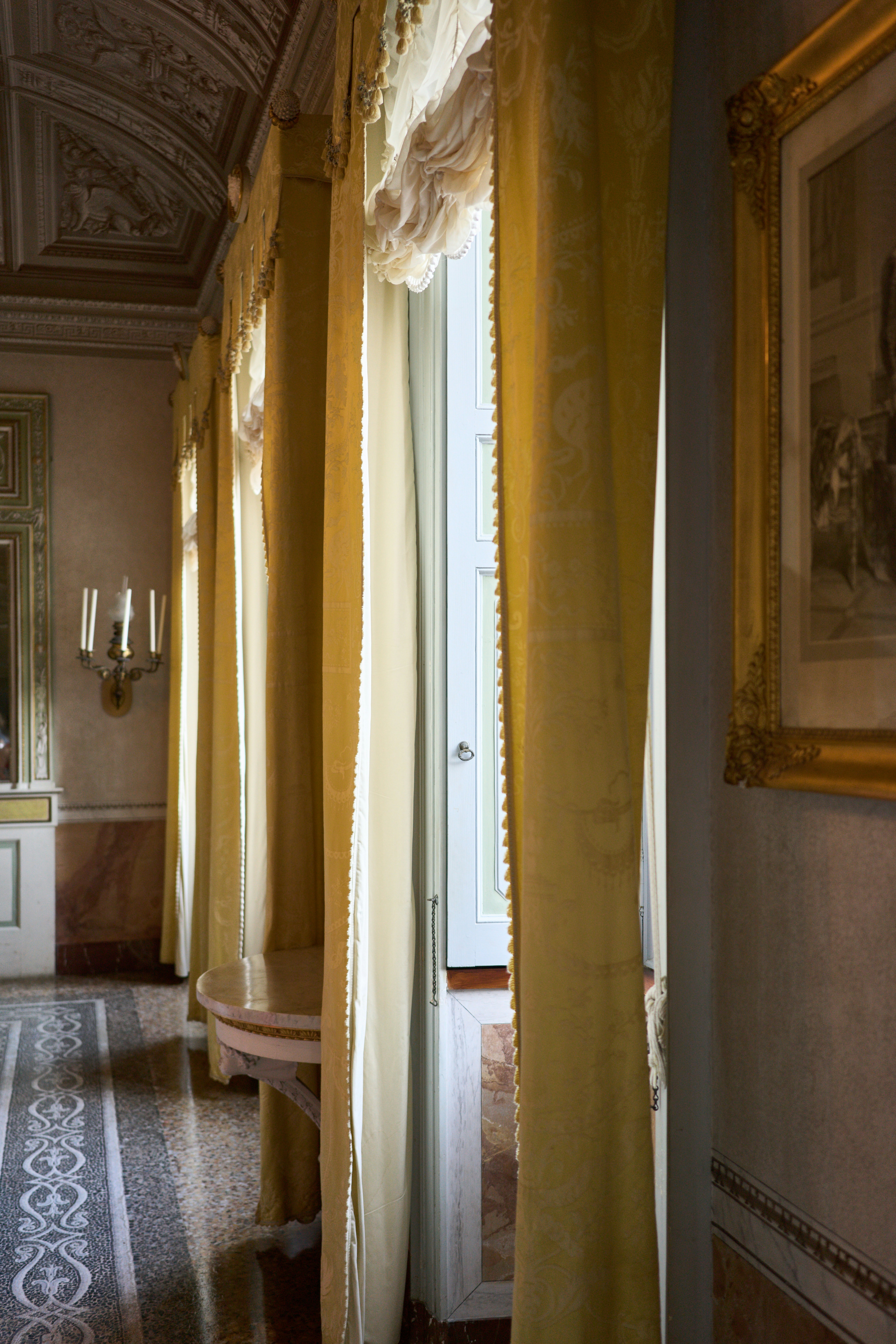 An elegant room with yellow curtains and artwork.