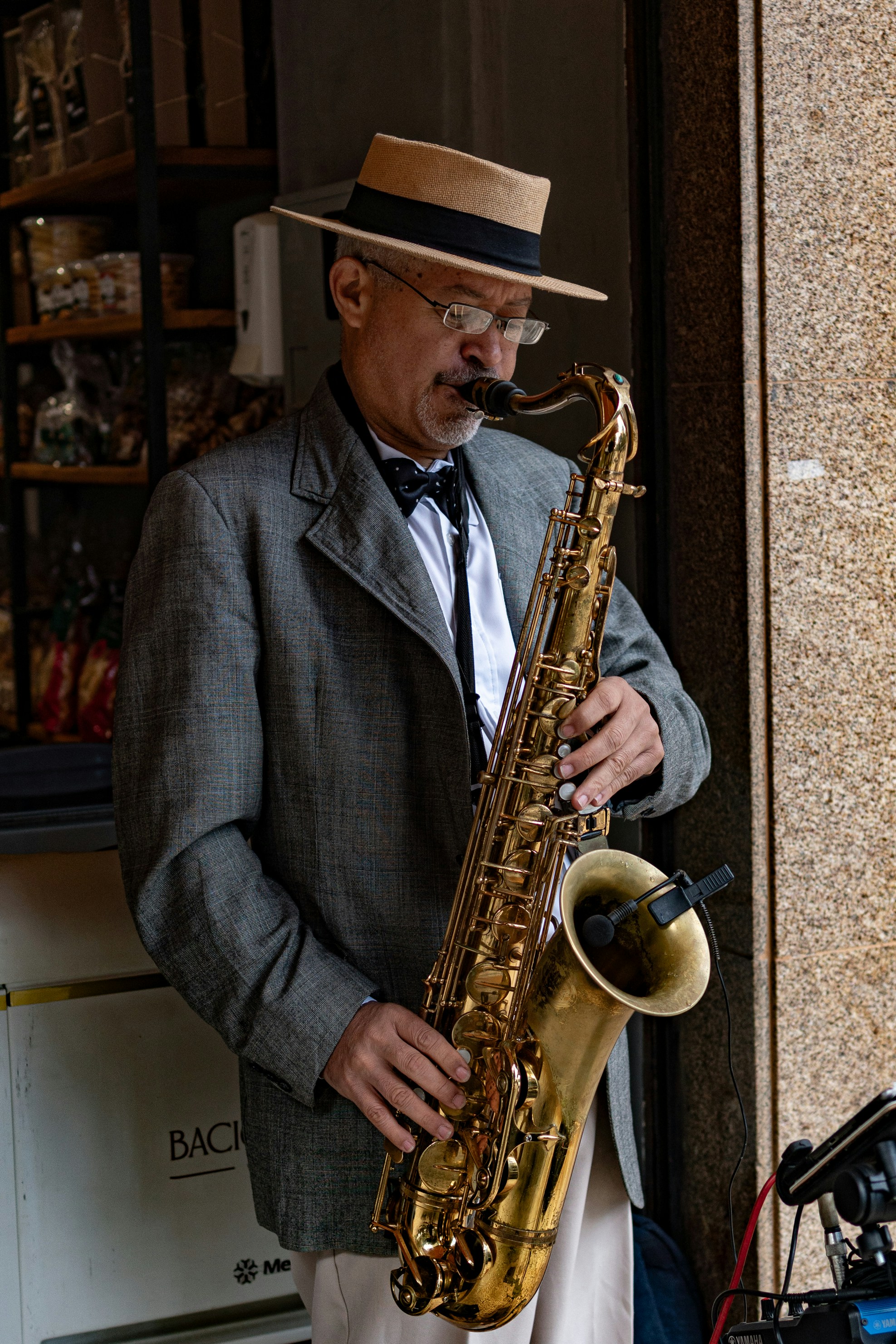 A man in a suit plays the saxophone.