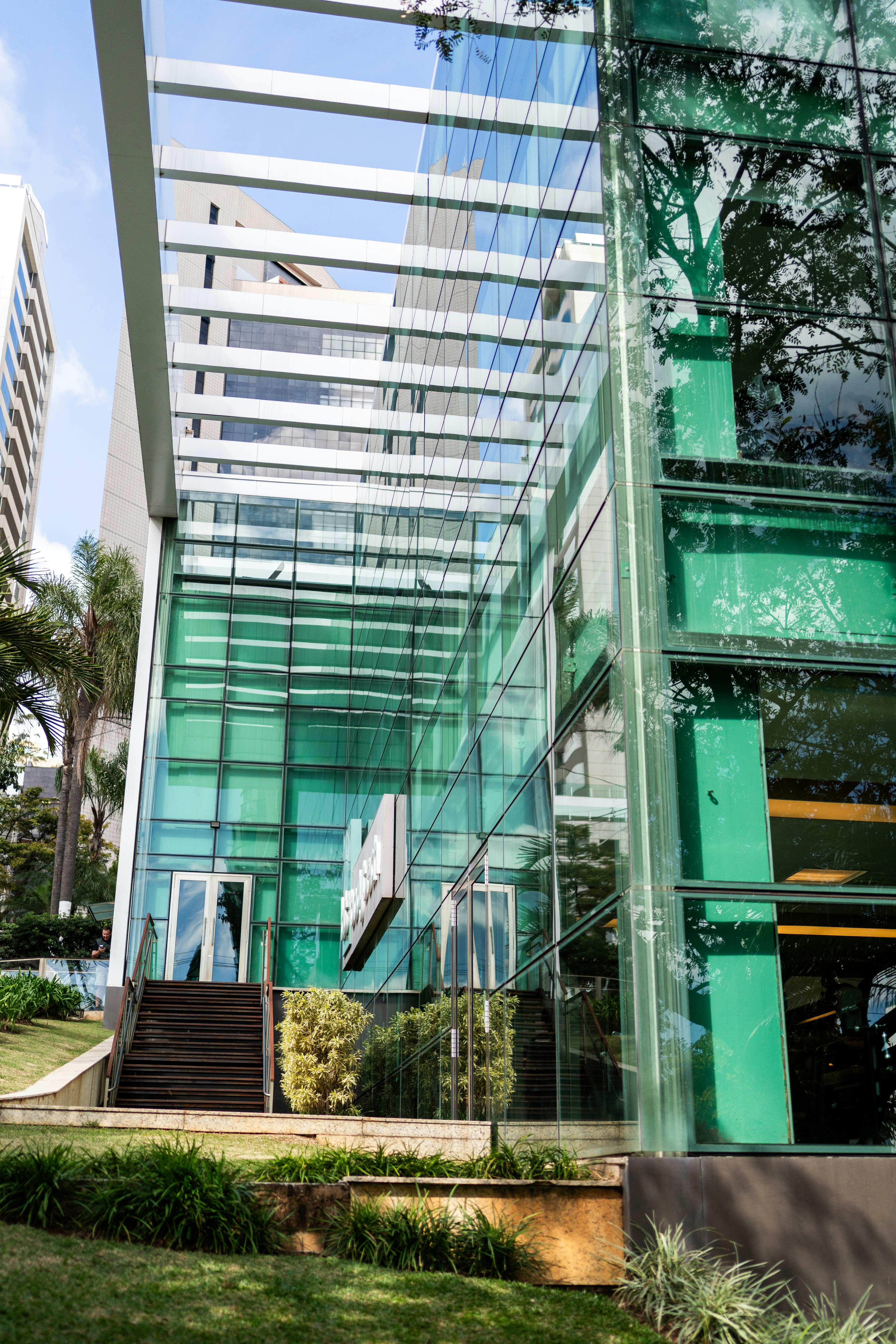 Modern building with glass facade and green accents.