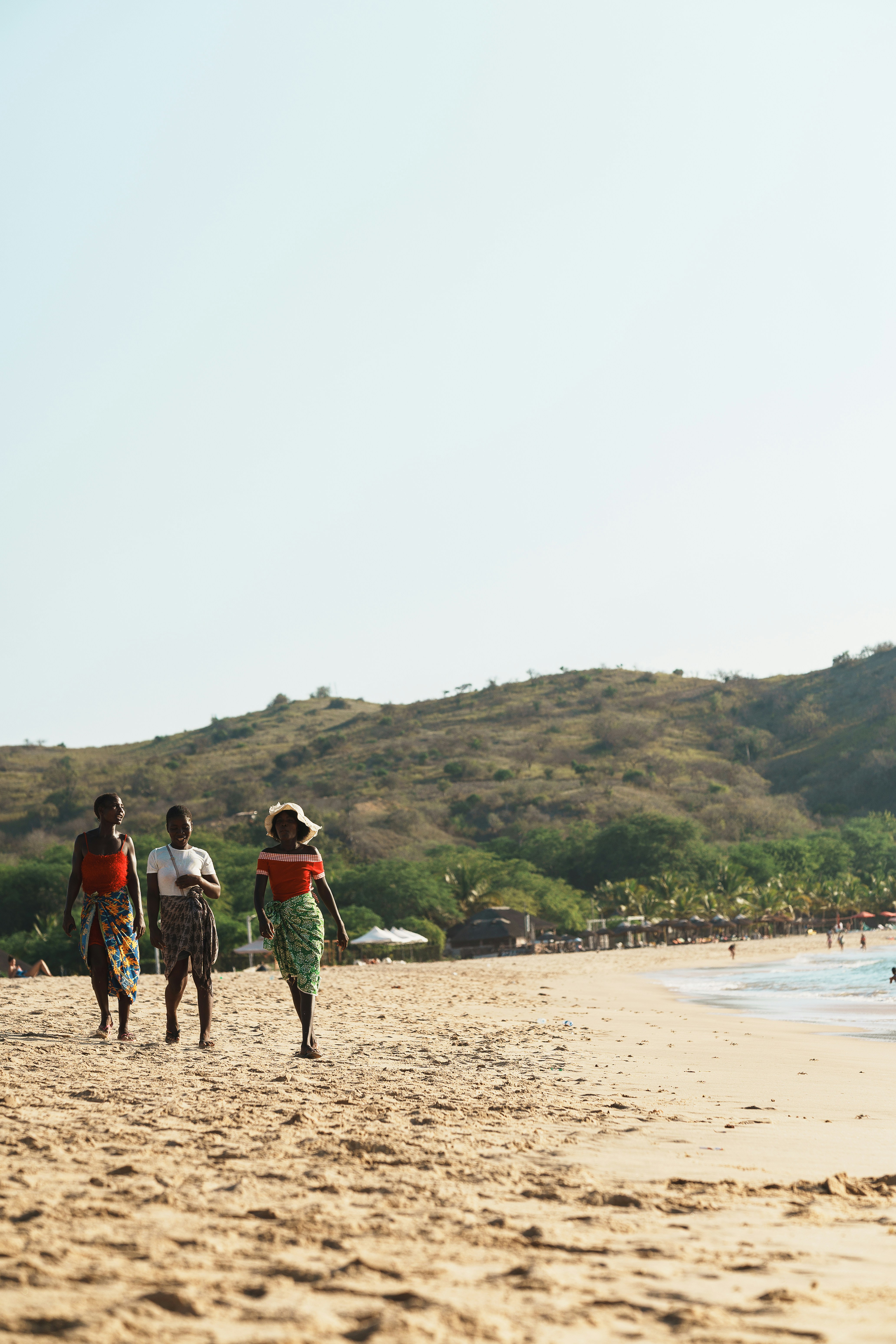 People stroll along the beach on a sunny day.