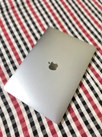 A macbook is shown on a checkered pattern.