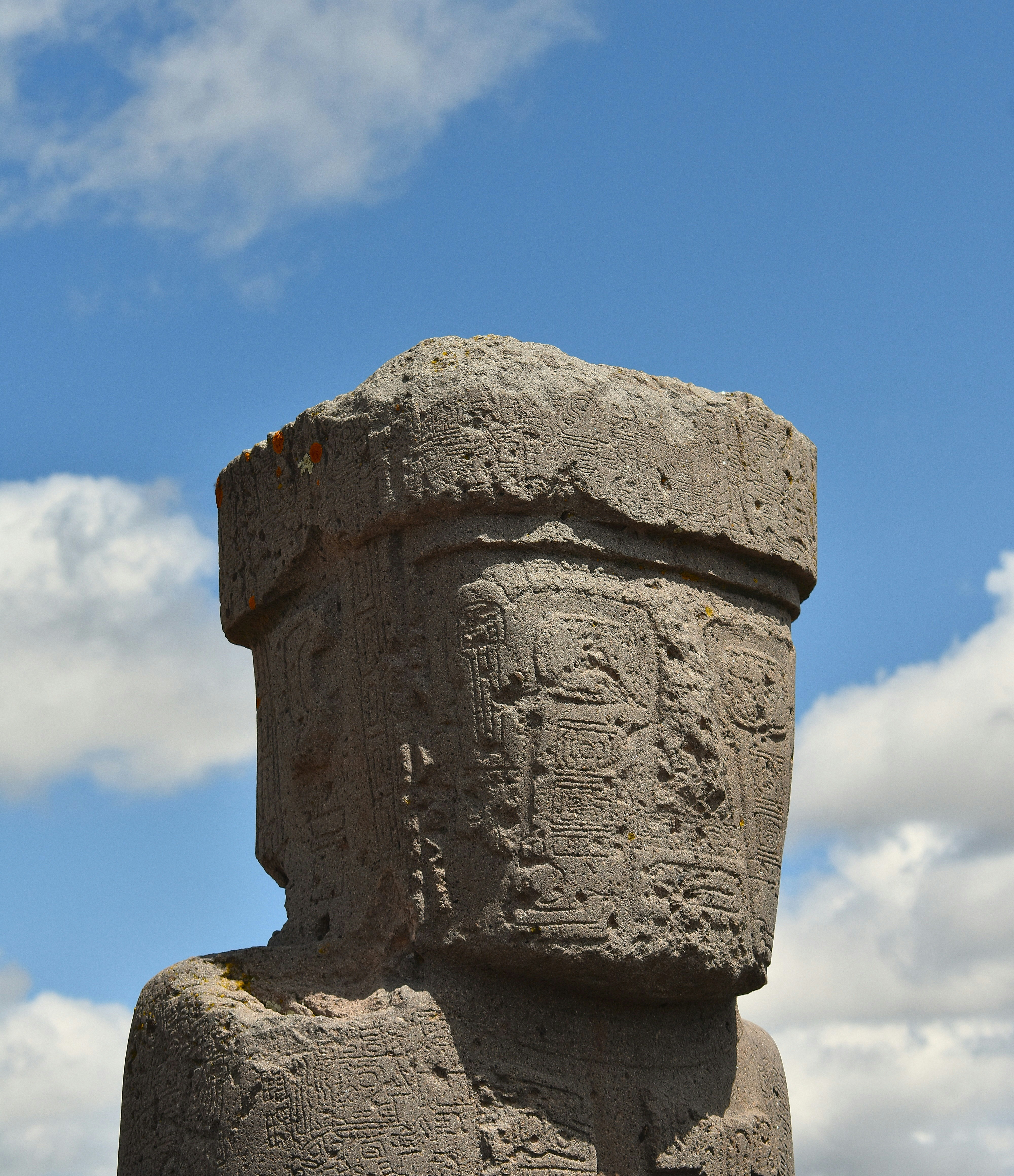 An ancient stone statue stands against a blue sky.