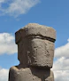 An ancient stone statue stands against a blue sky