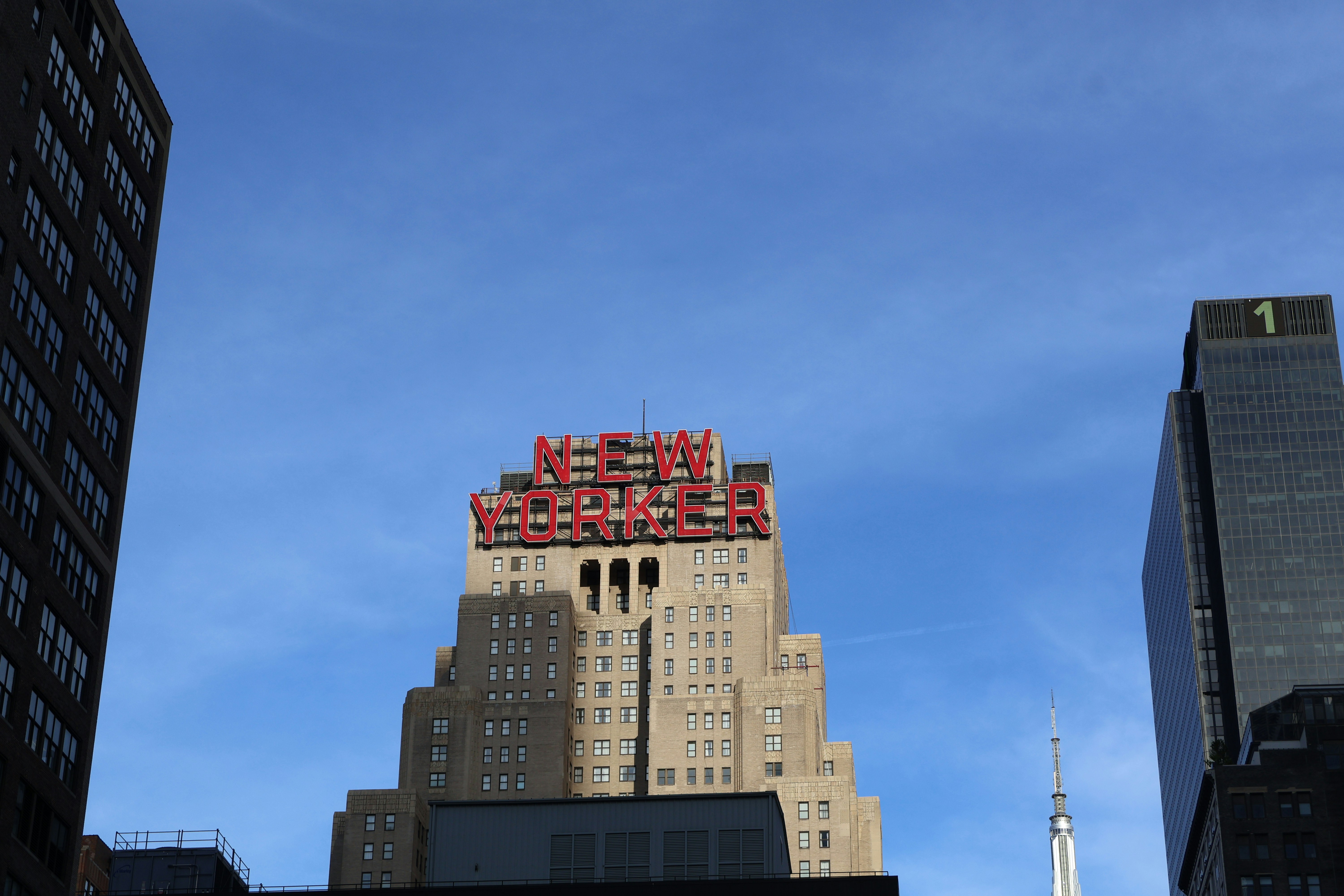 A tall building stands against a blue sky.