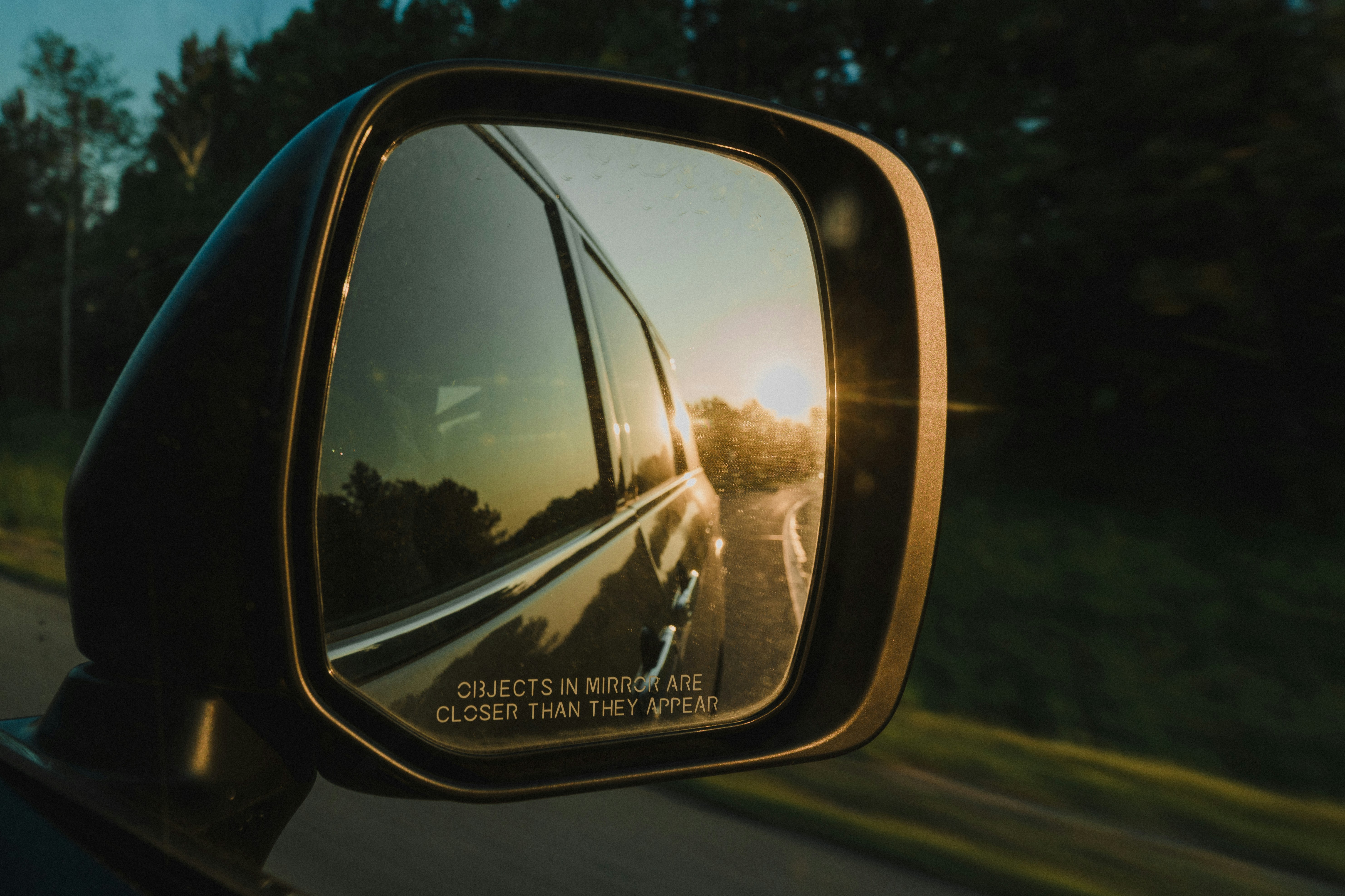 車のサイドミラーに映る夕焼け。