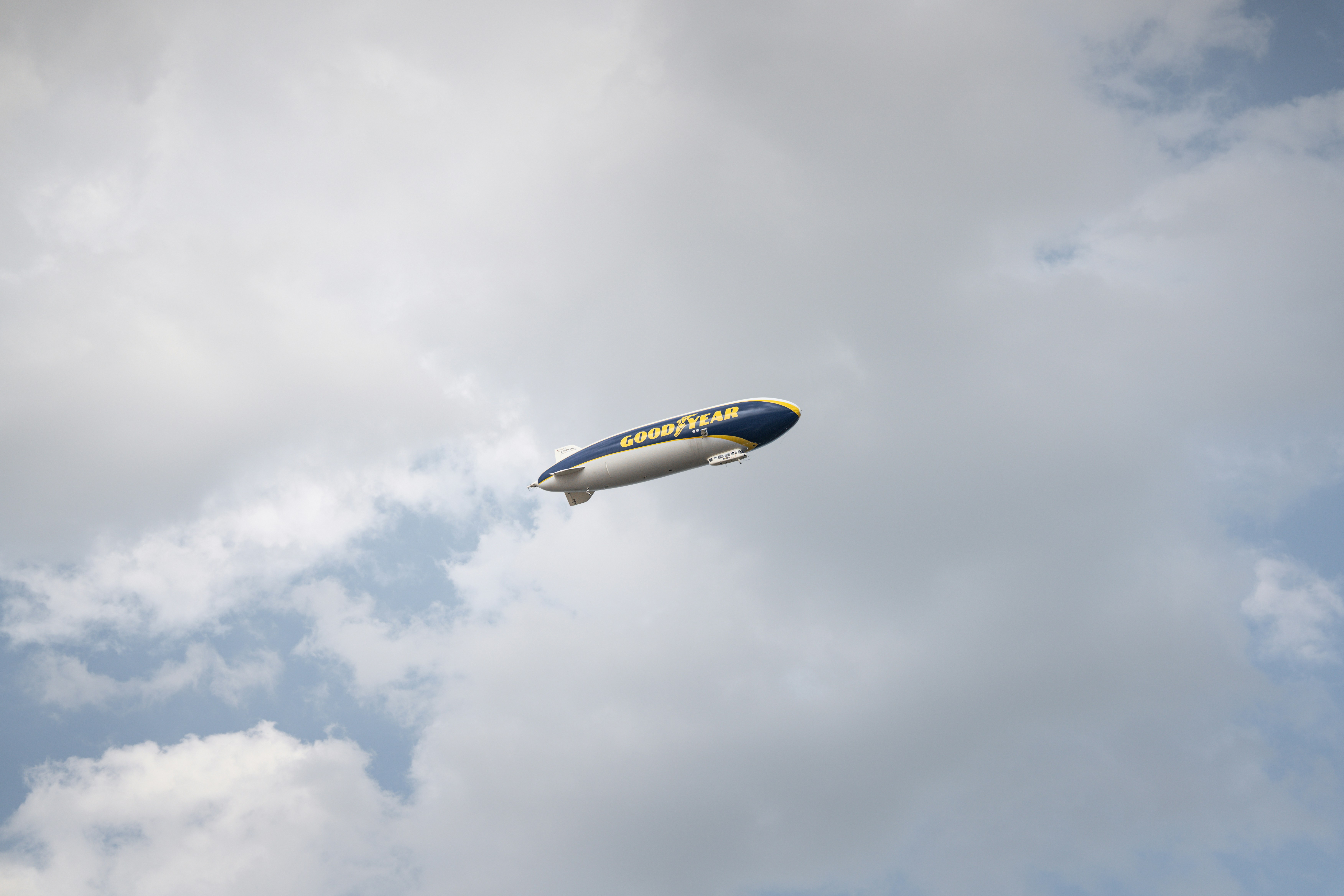 A blimp floats against a cloudy sky.