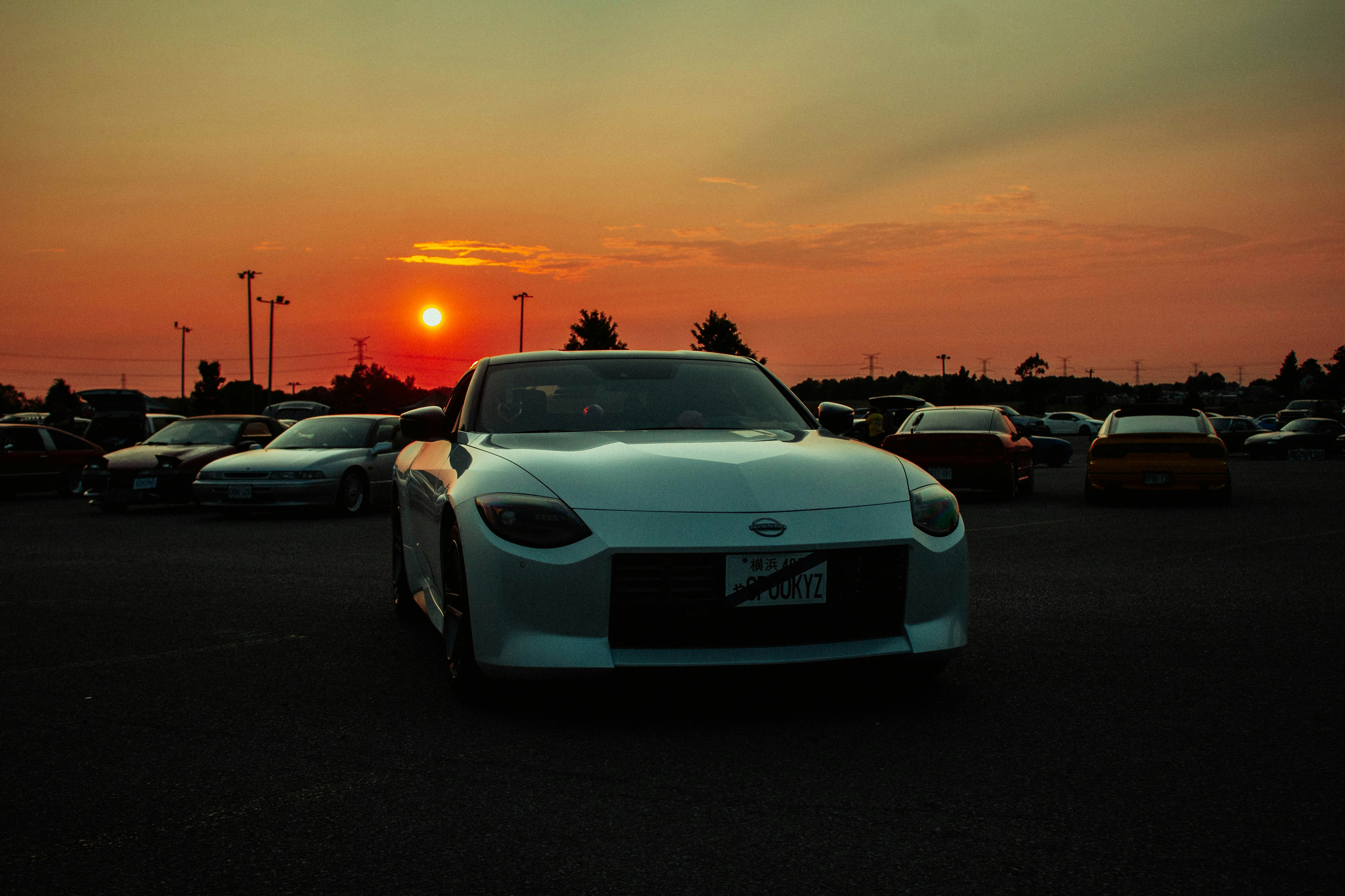 Row of late‑model used electric cars parked at a dealership, ready for sale
