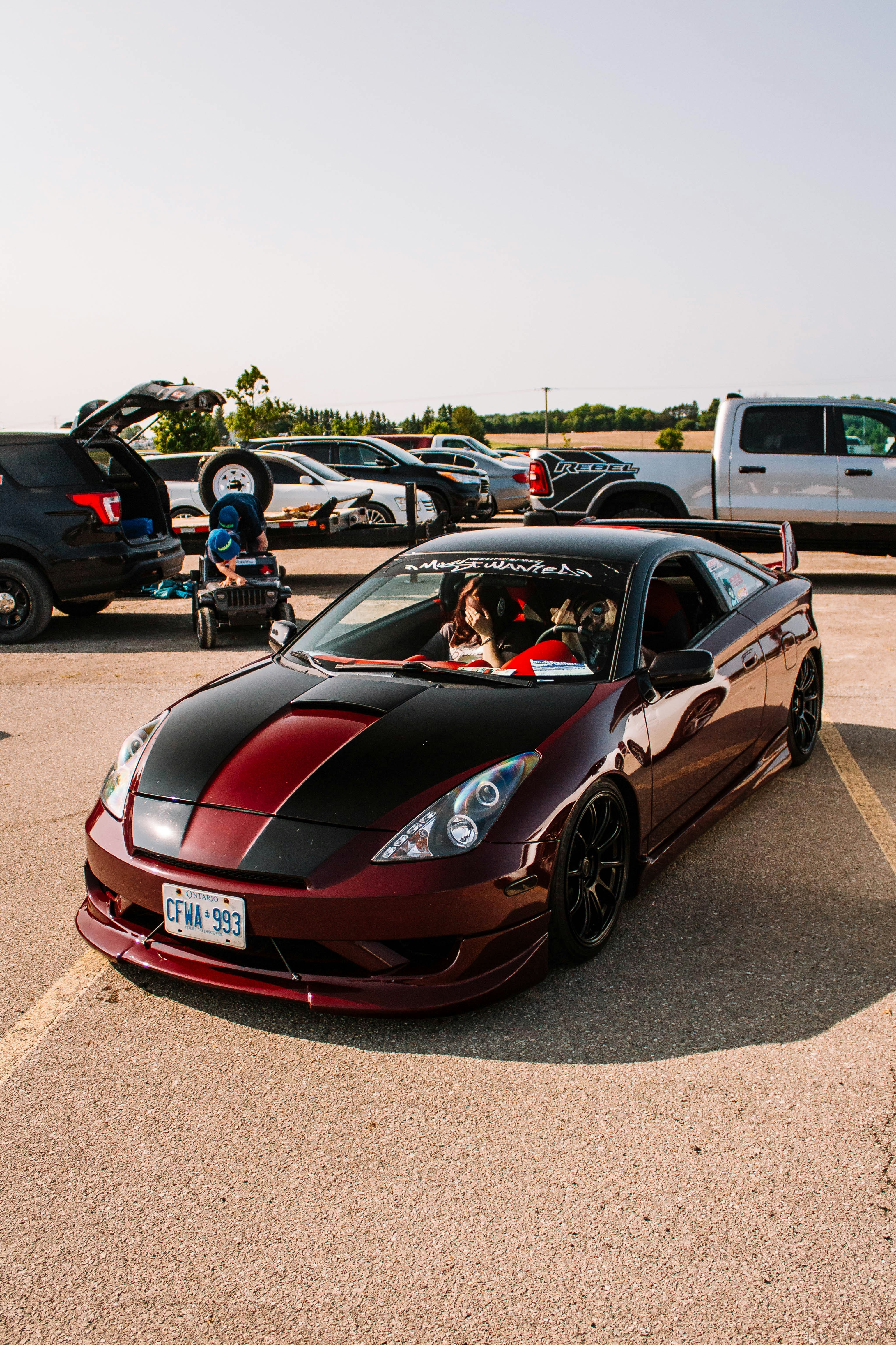A modified, shiny car is parked on the asphalt