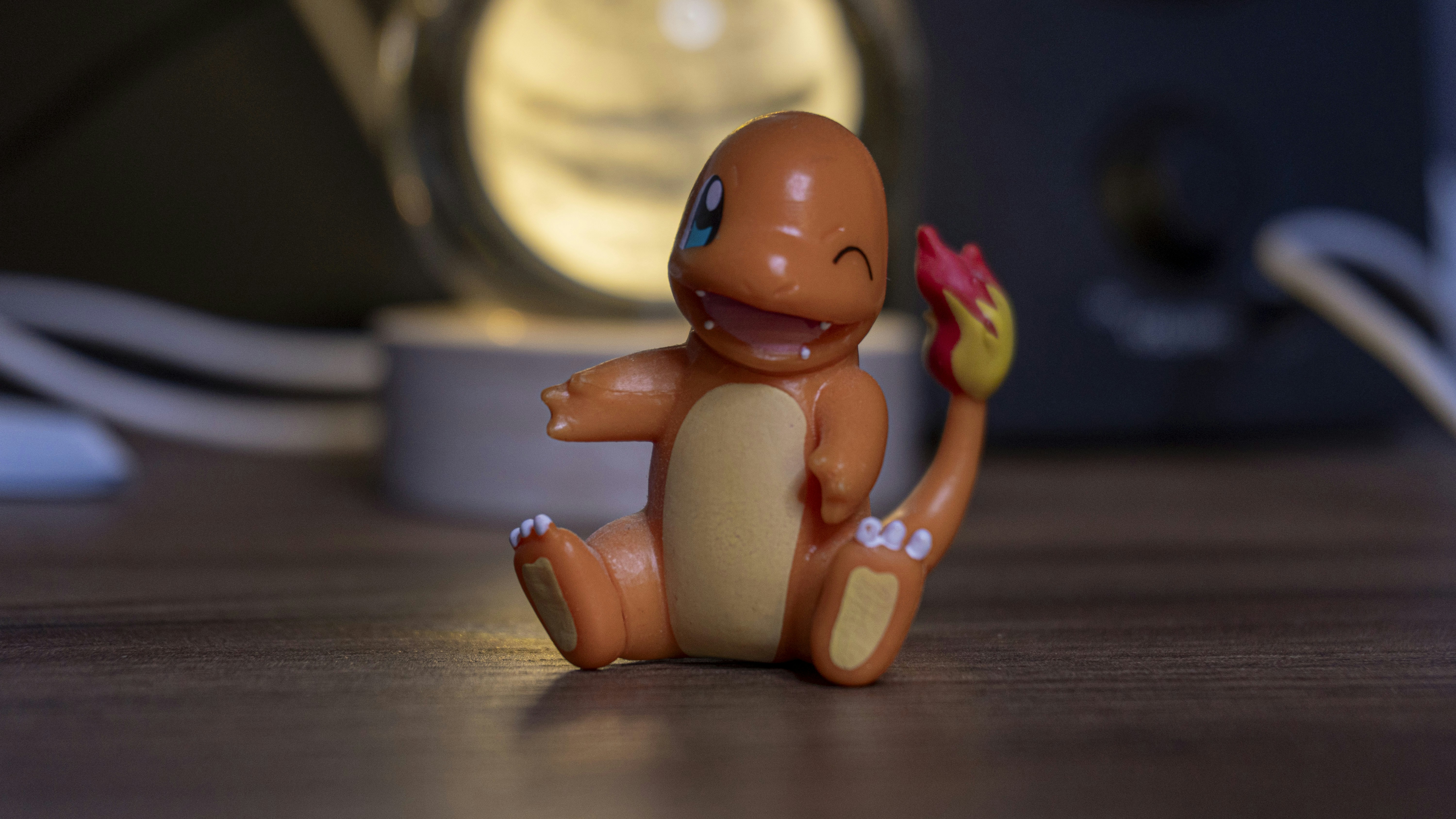 A charmander figurine sits smiling and winking.