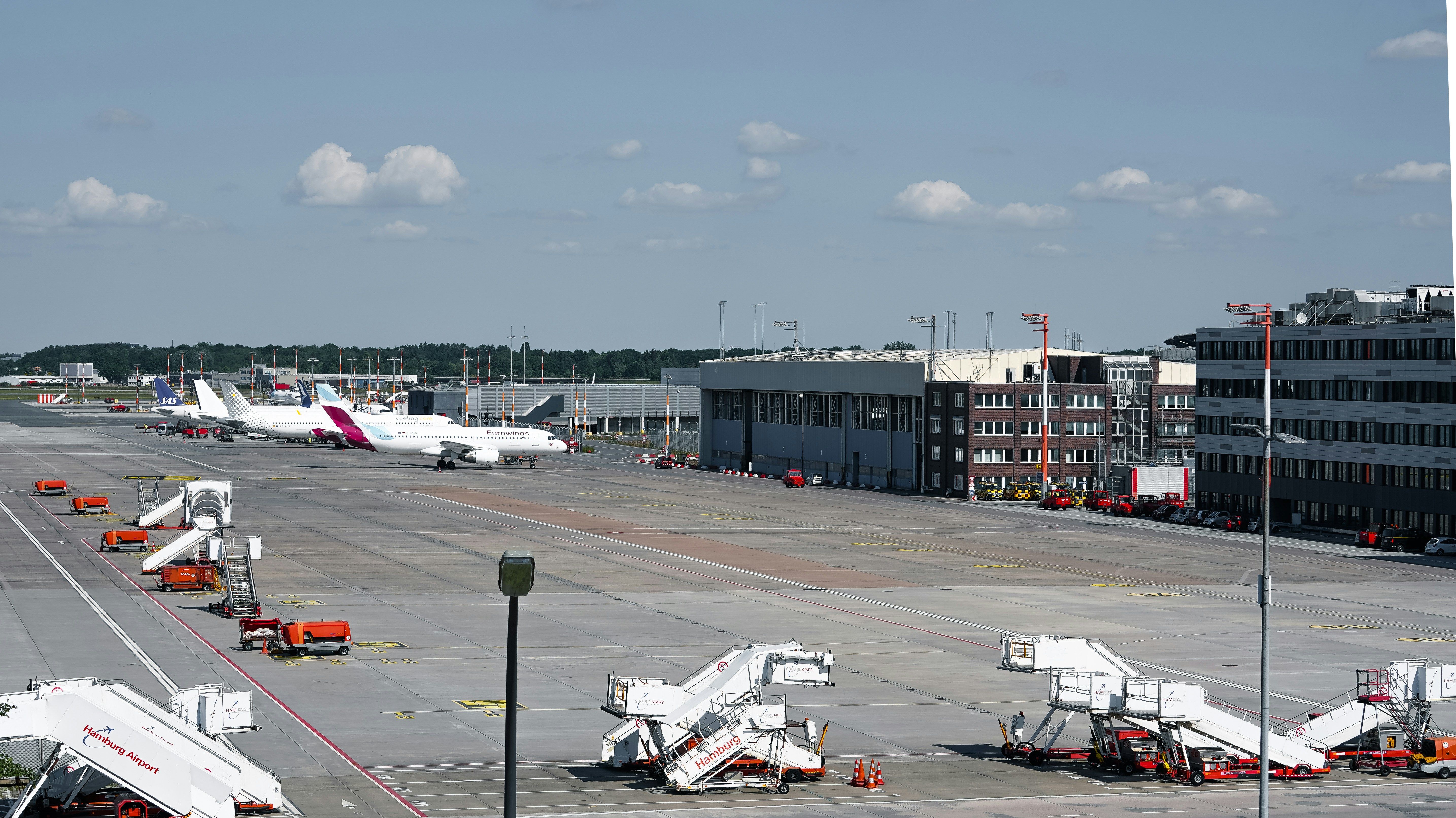 Airplanes and stairs are on the airport tarmac.