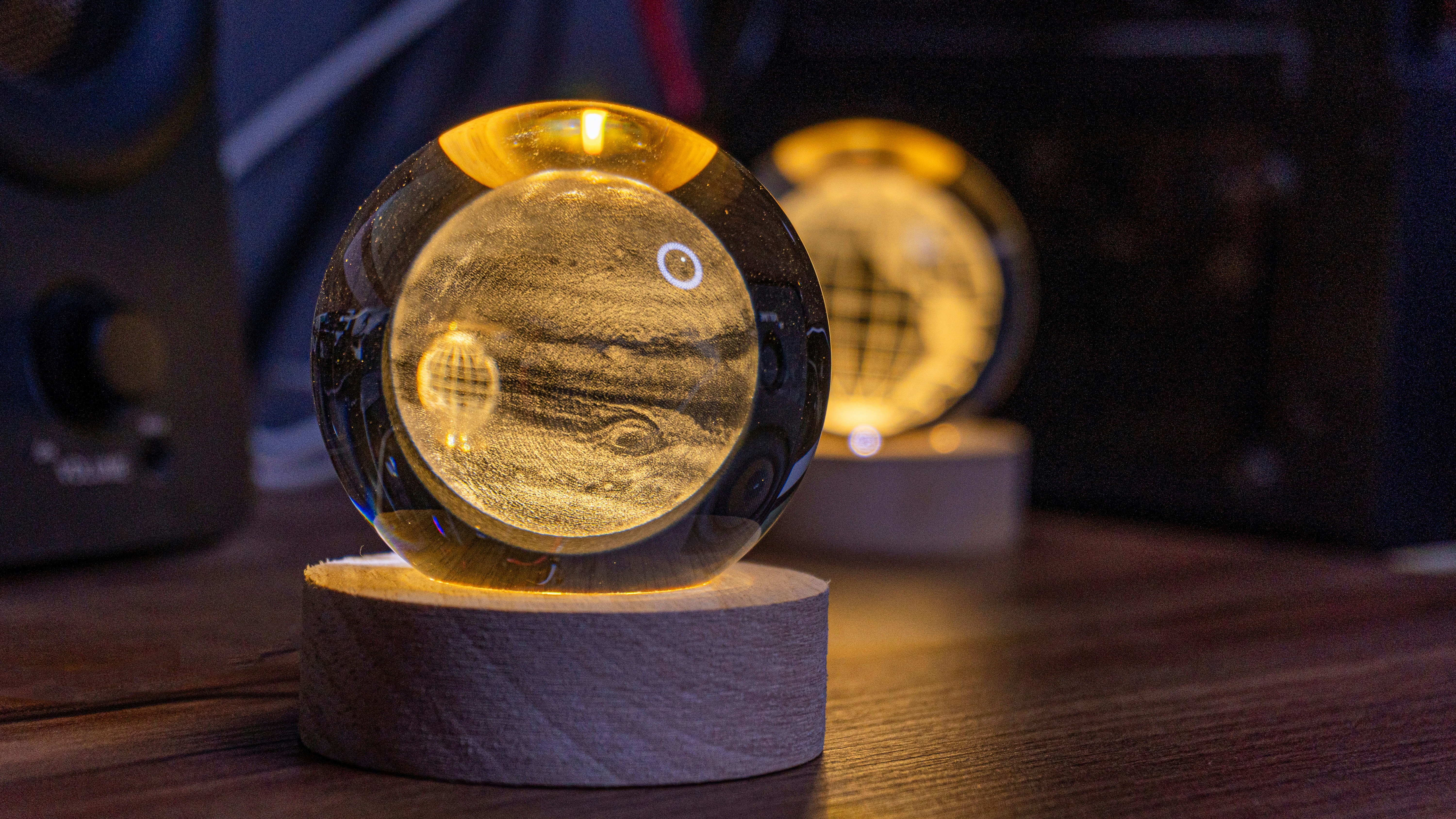 Illuminated planet globes sit on wooden bases.
