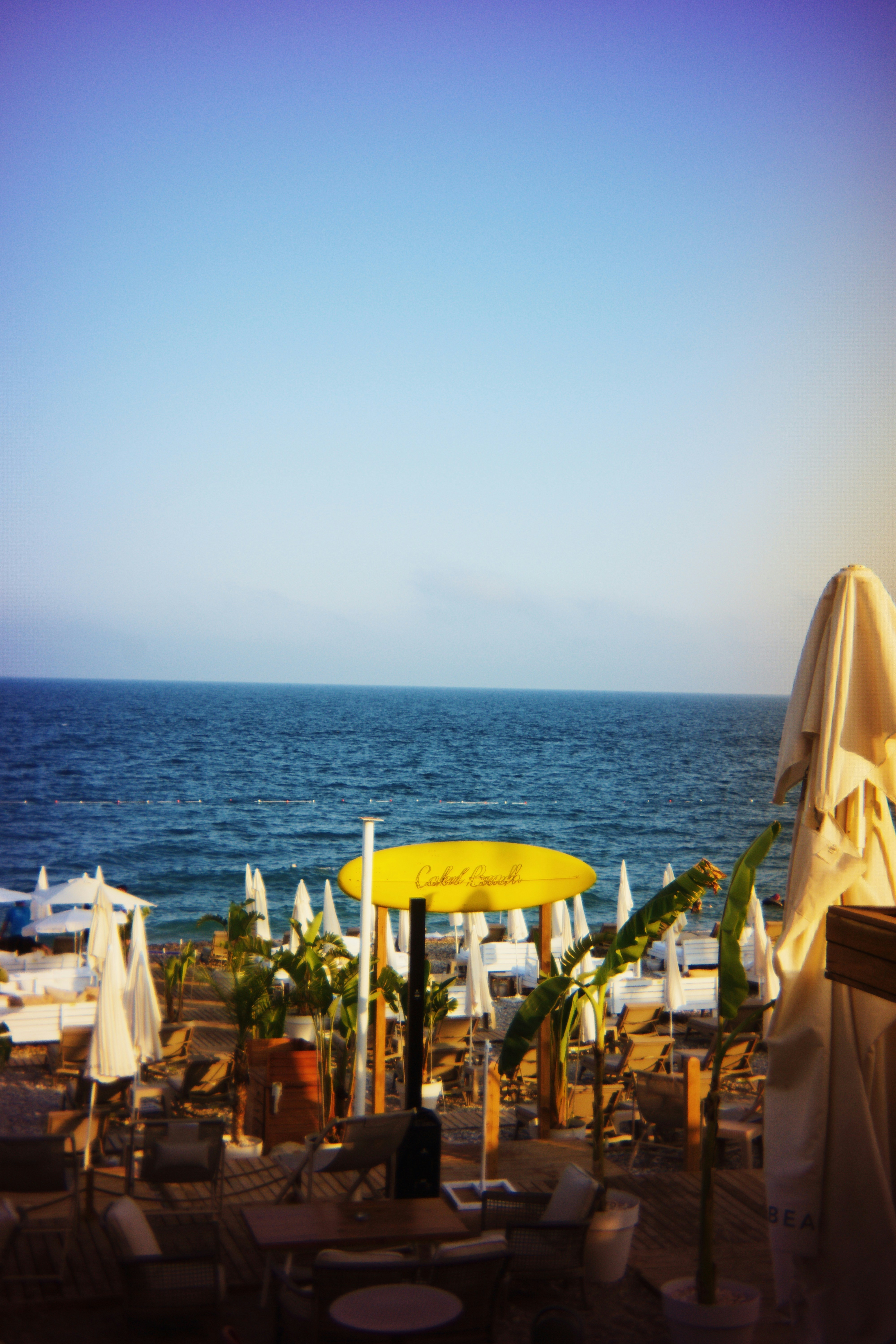 Beach umbrellas dot the sandy beach and serene ocean.