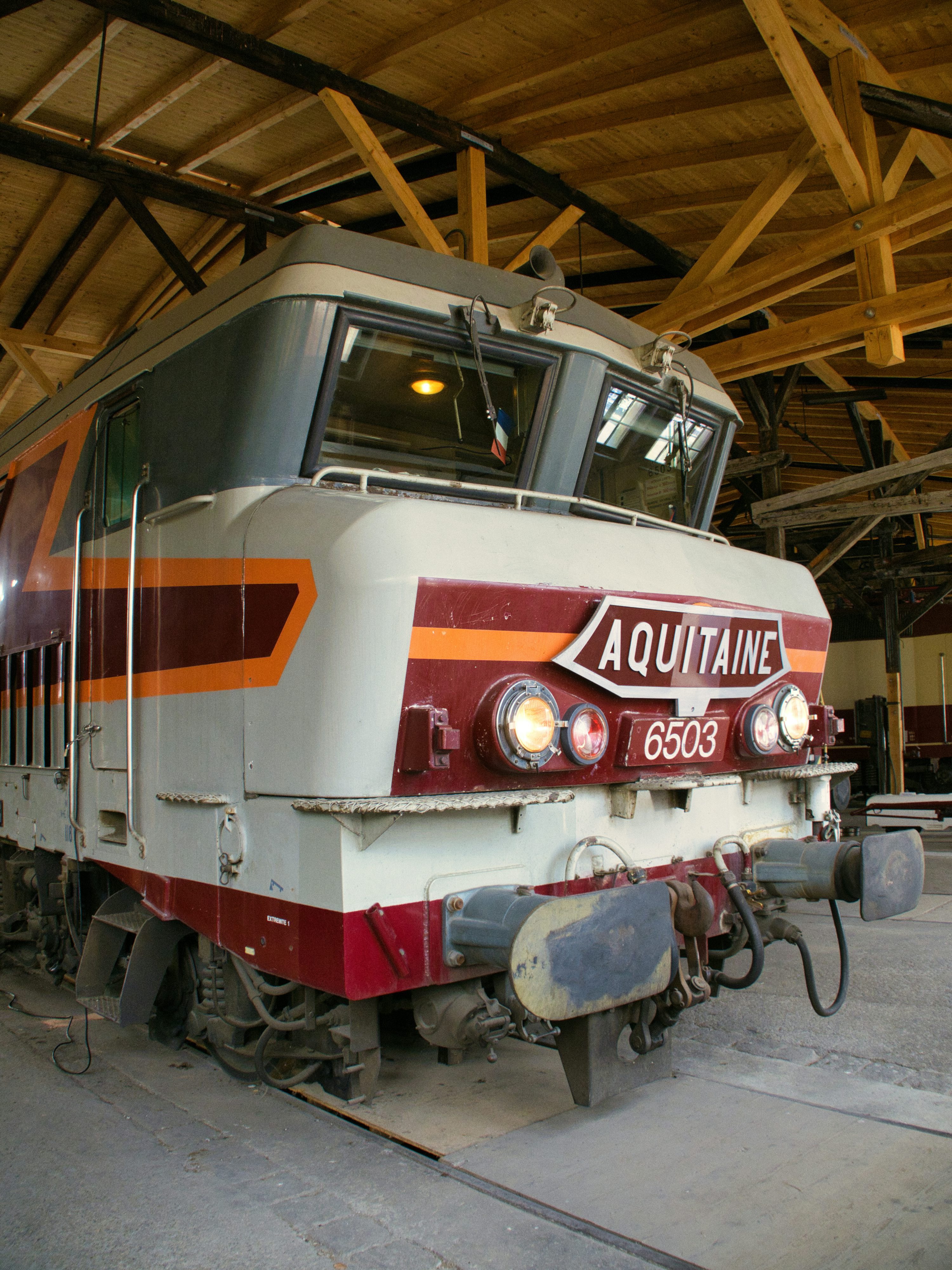 A train labeled "aquitaine" is inside a shed.