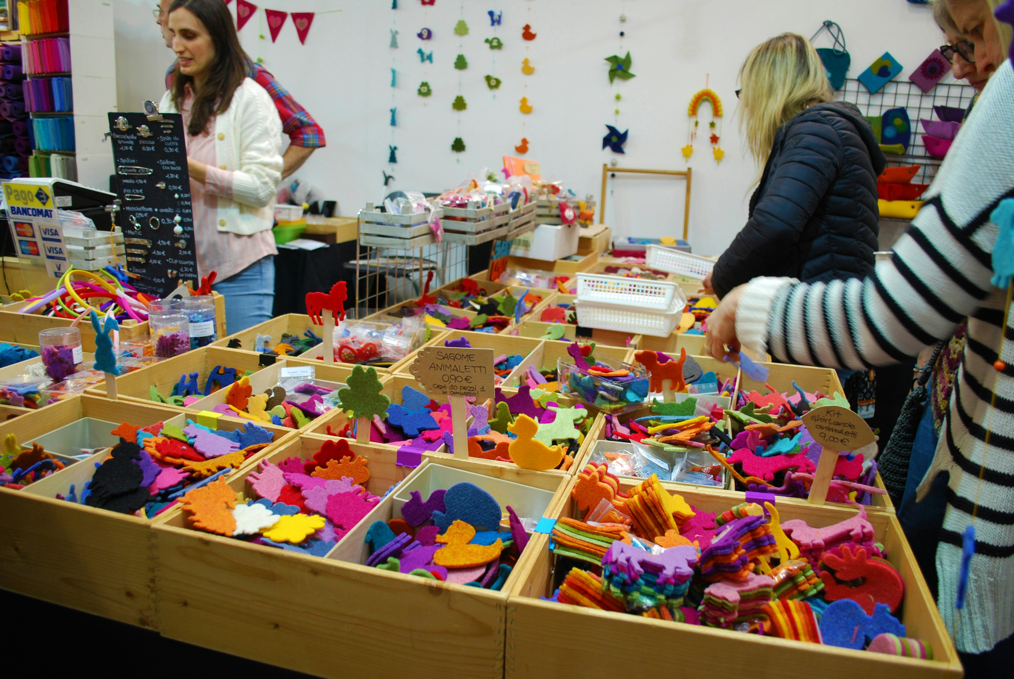 People browse colorful crafts at a market.