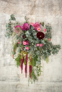 Floral arrangement against a textured, light-colored wall.