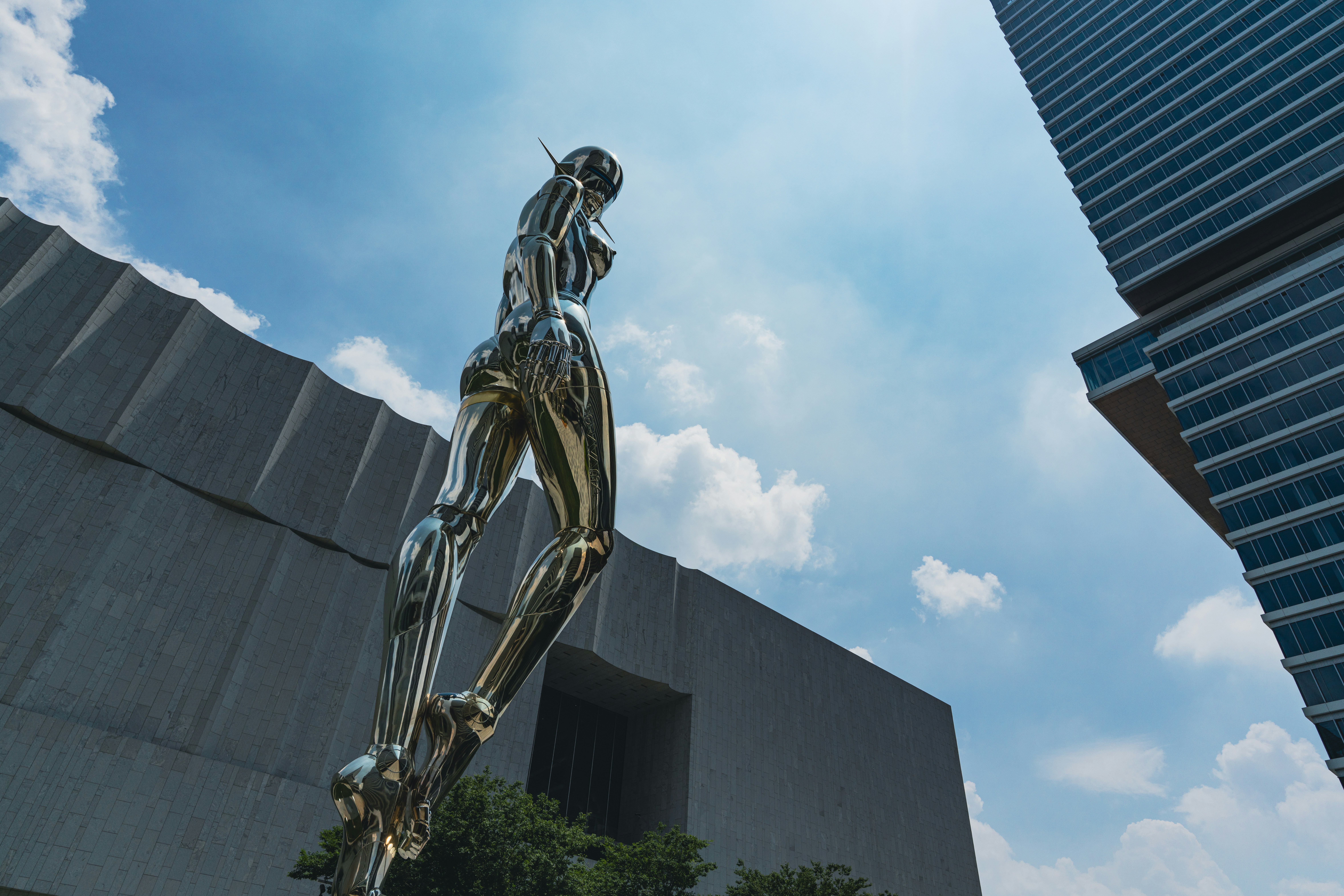 A shiny sculpture is displayed outdoors by buildings. photo – Free ...