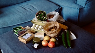 Groceries are arranged on a blue sofa.