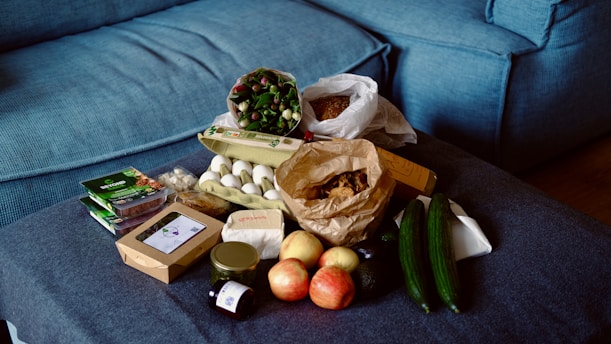 Groceries are arranged on a blue sofa.