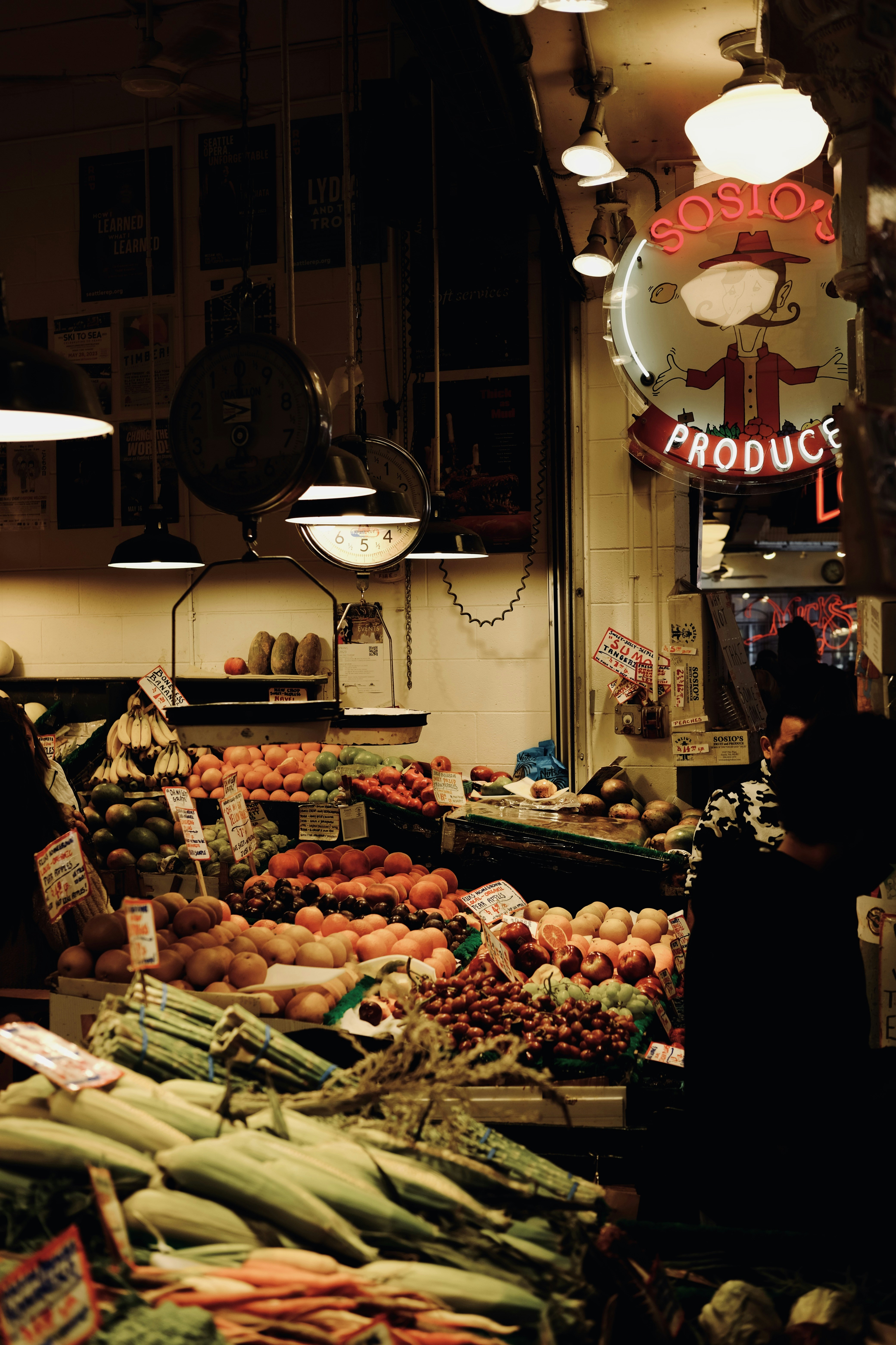 A fruit stand glows with neon signs.