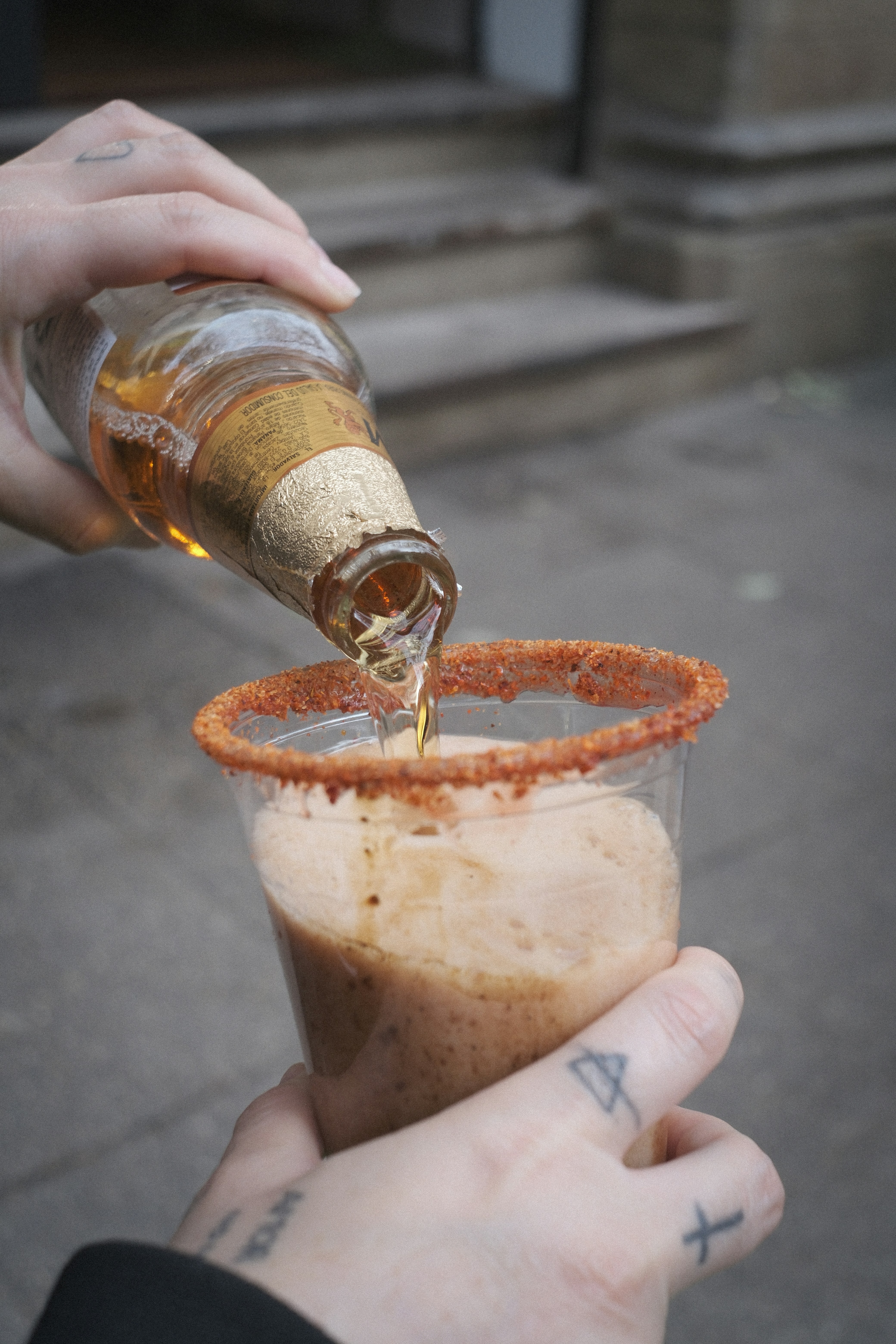 Beer is being poured into a spicy rimmed glass.