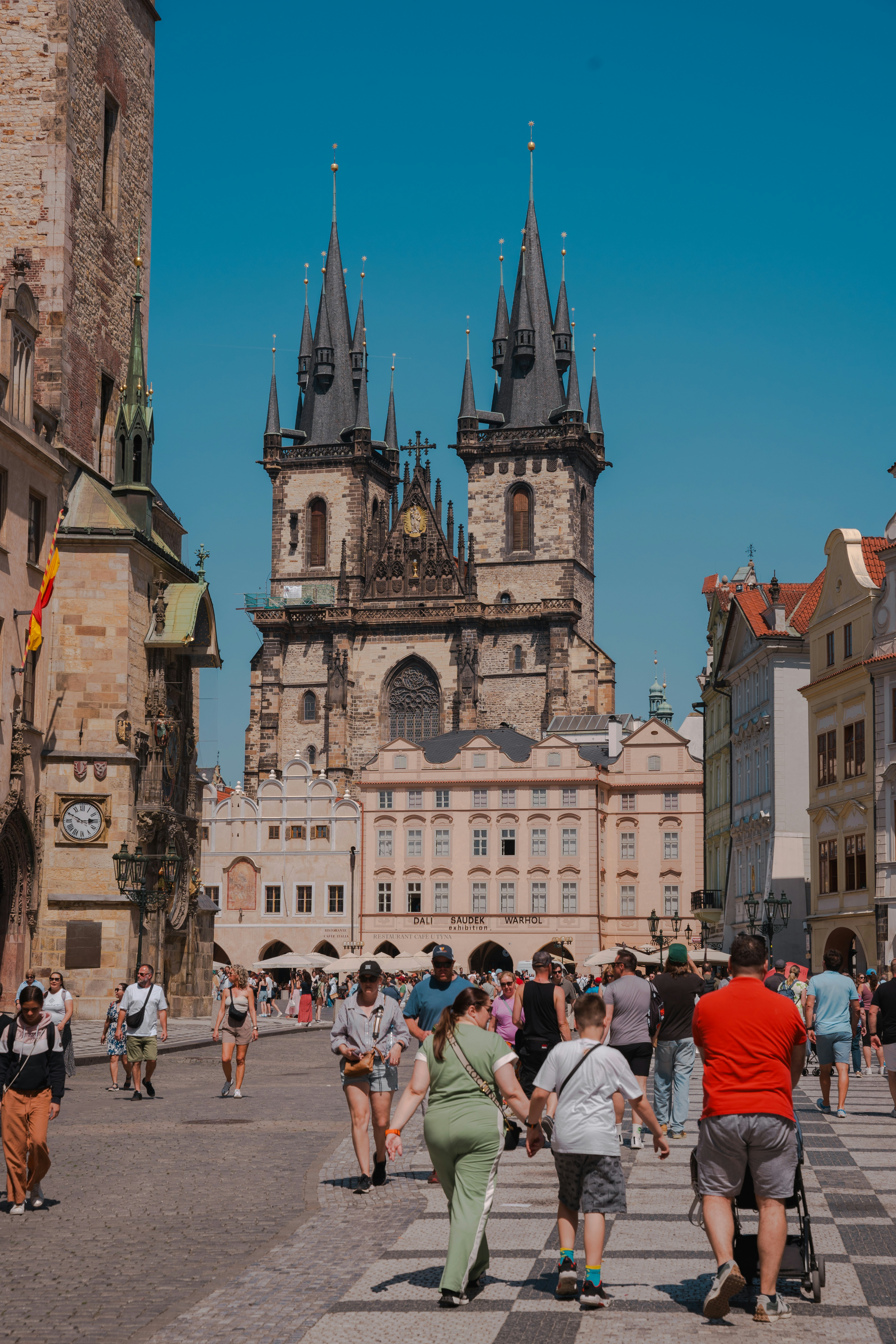 People walk on a square in front of a church.