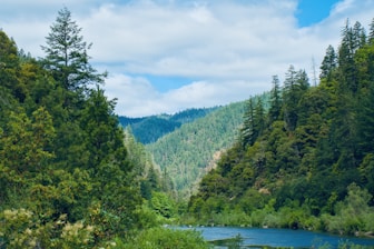 Beautiful green valley with a river and cloudy sky.