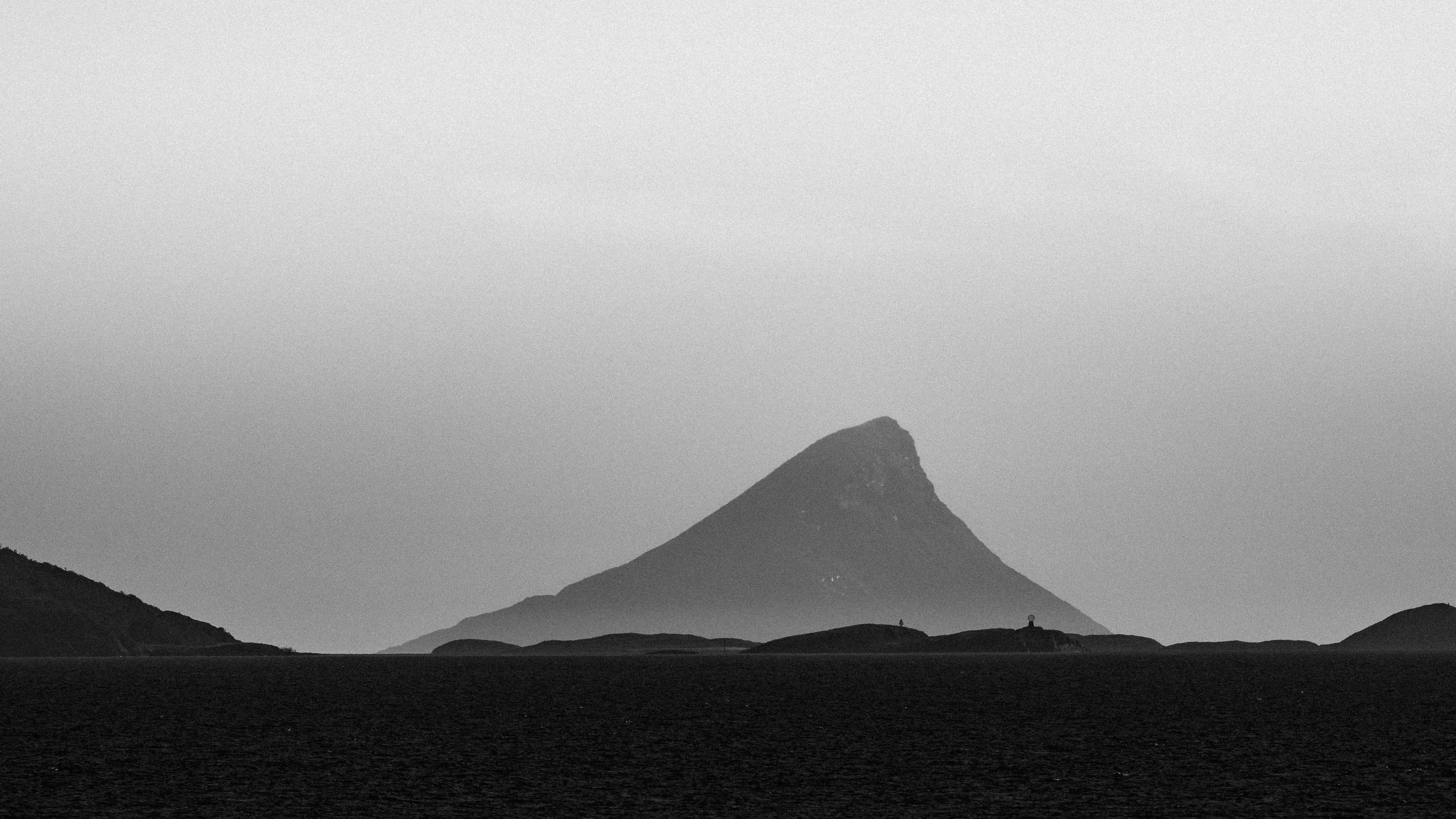A mountain peak silhouetted against a cloudy sky.