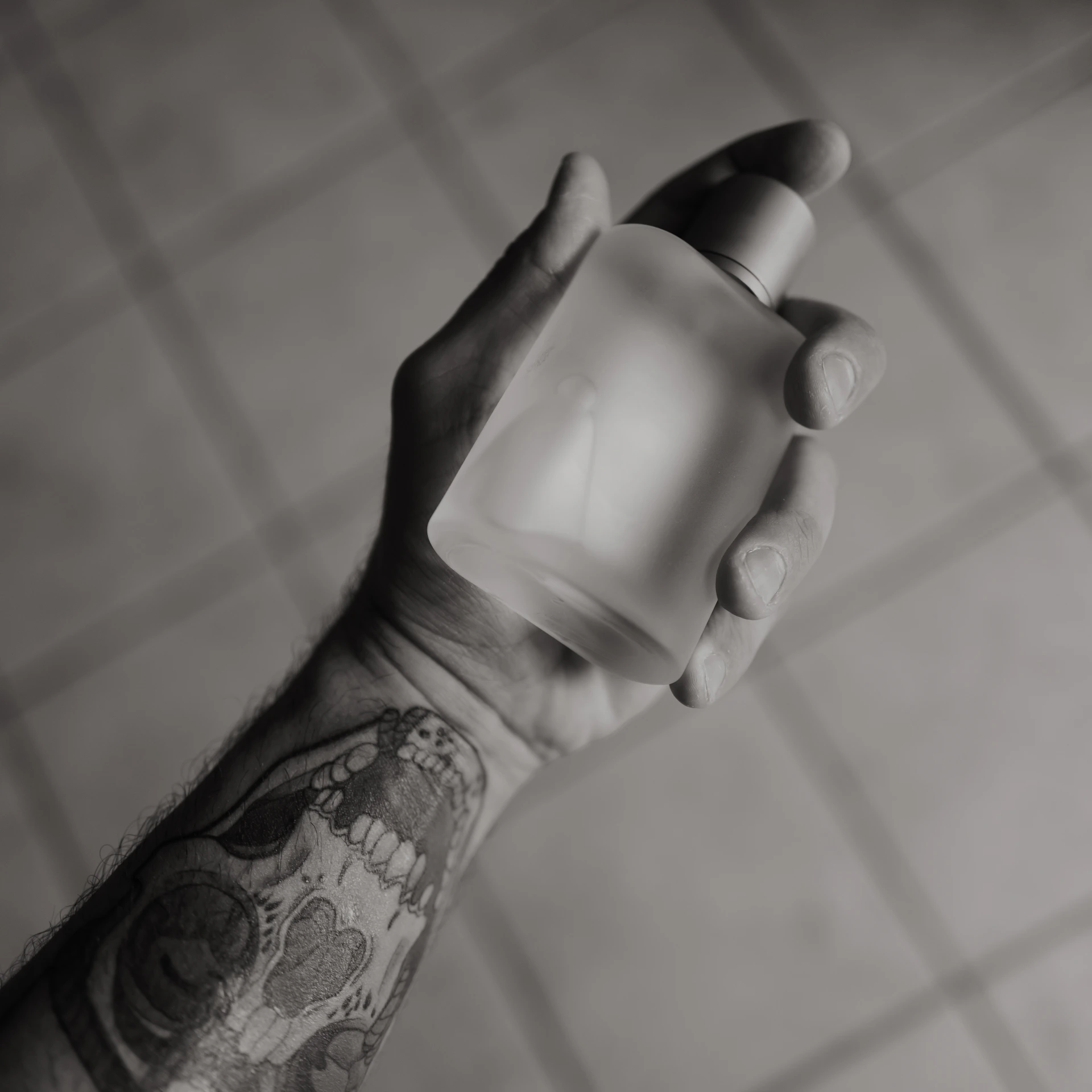 A hand holds a perfume bottle.