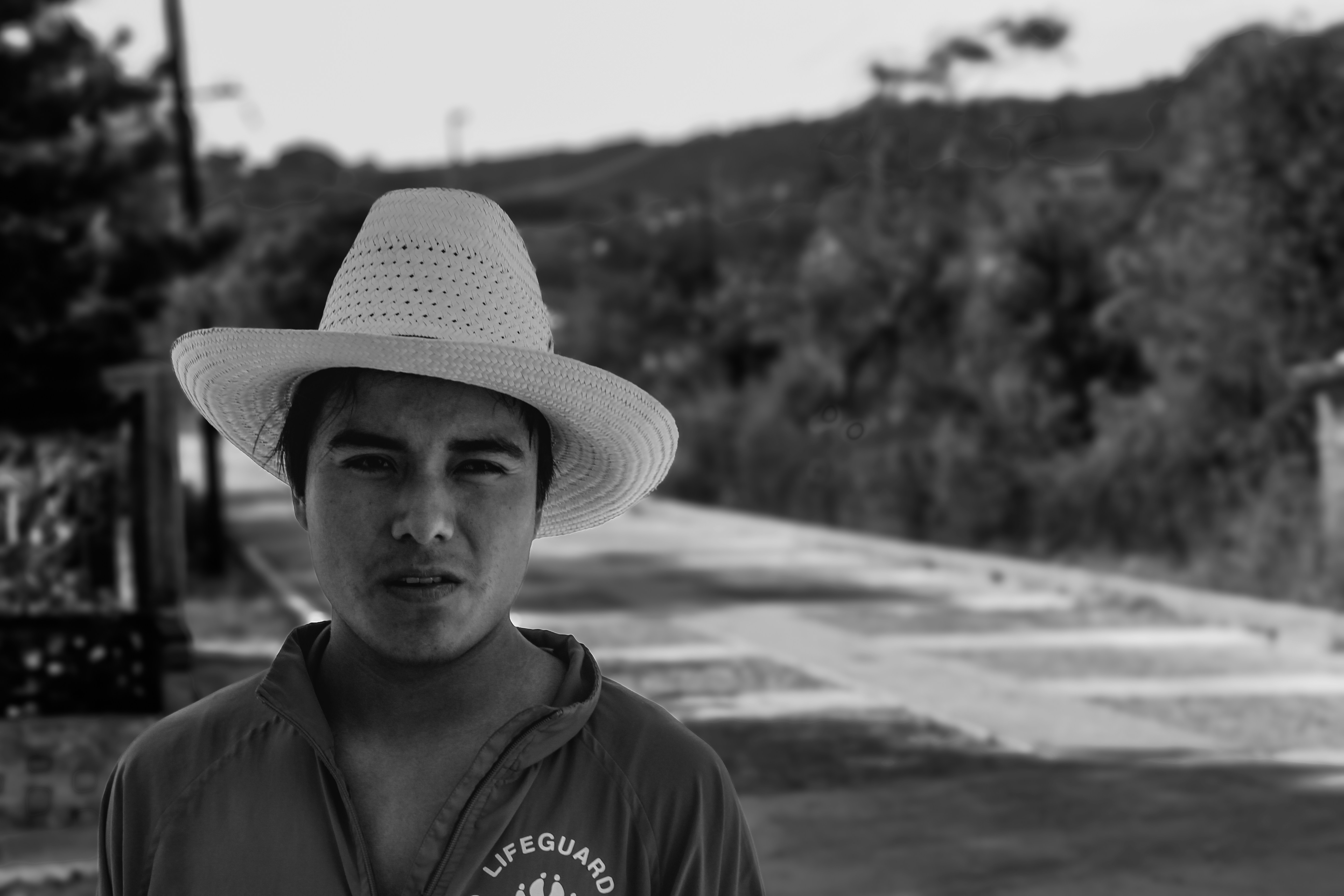 Young man with a hat stares at the camera.