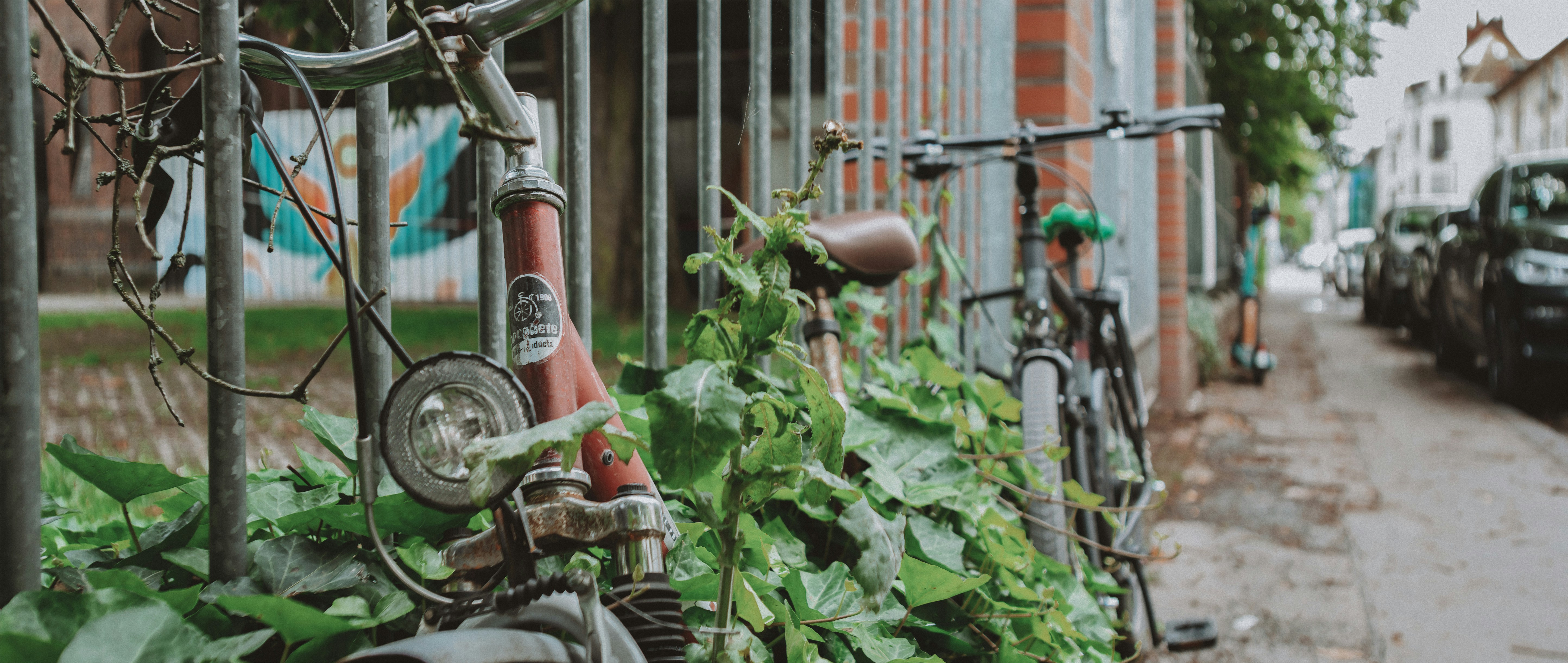 Bikes leaning against a fence on a city street.