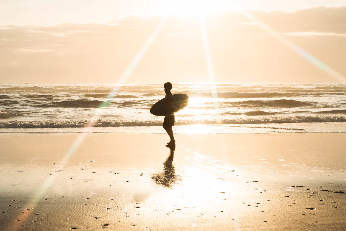 Surfer enjoying the sunrise at the beach. Photo by Beckett Zapp on Unsplash