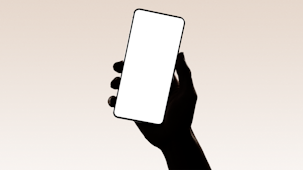 A hand silhouetted holding a smartphone.
