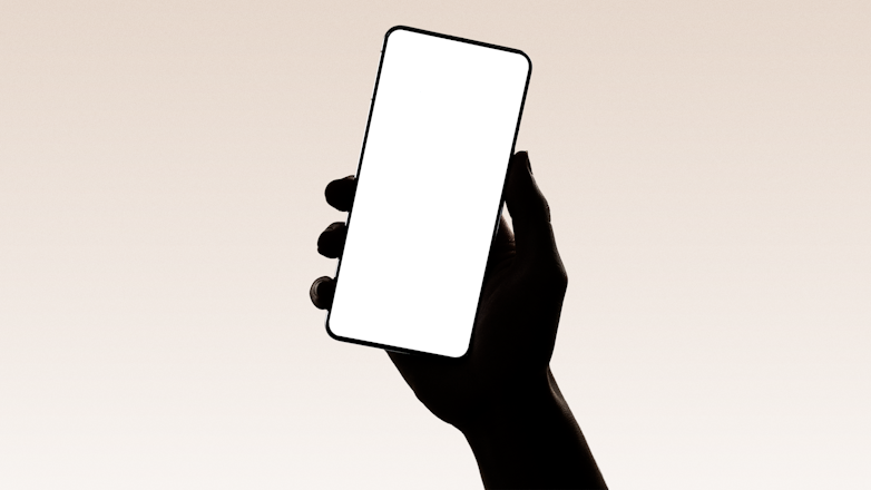 A hand silhouetted holding a smartphone.